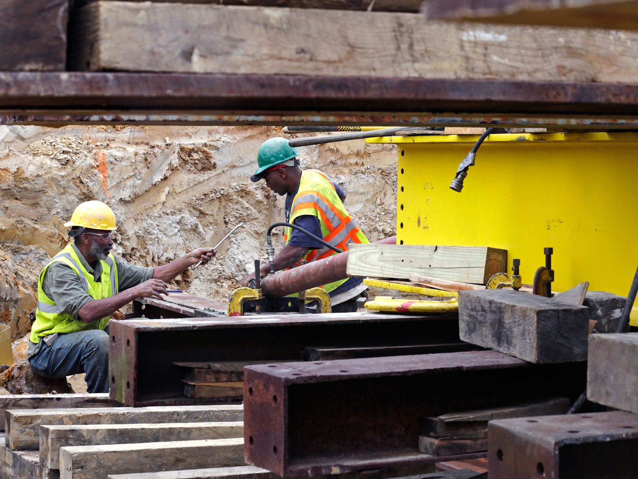 Workers adjust the bracket on a hydraulic piston to ensure a smooth move