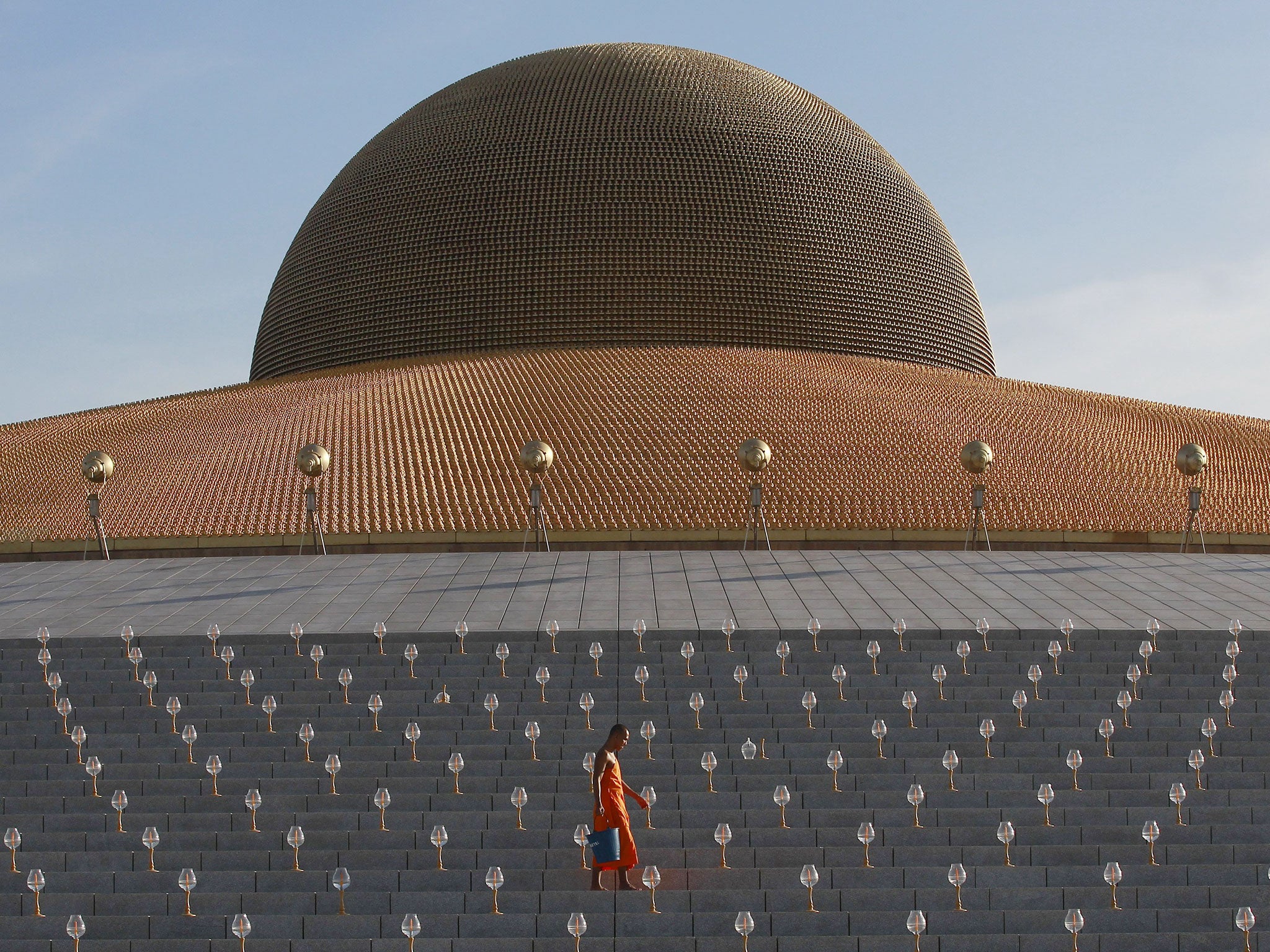 A Buddhist monk inspects candles during Vesak Day, an annual celebration of Buddha's birth, enlightenment and death, at Wat Dhammakaya temple in Pathum Thani province, on the outskirts of Bangkok, Thailand