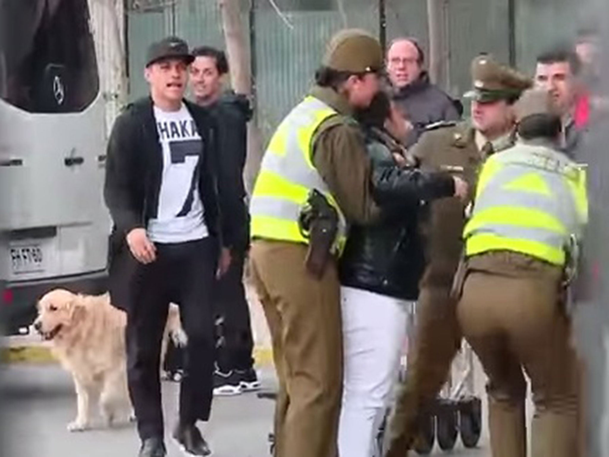 Alexis Sanchez approaches the fan who is being held by police