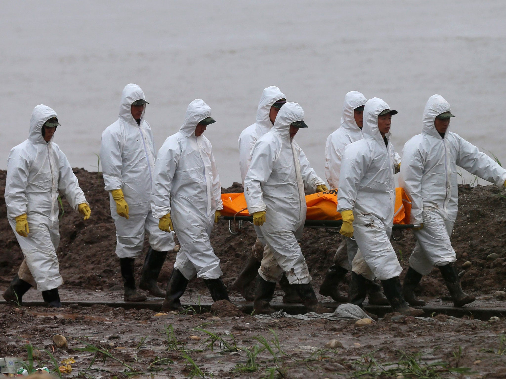 Rescuers carry a victim’s body from the capsized ship in the Yangtze River