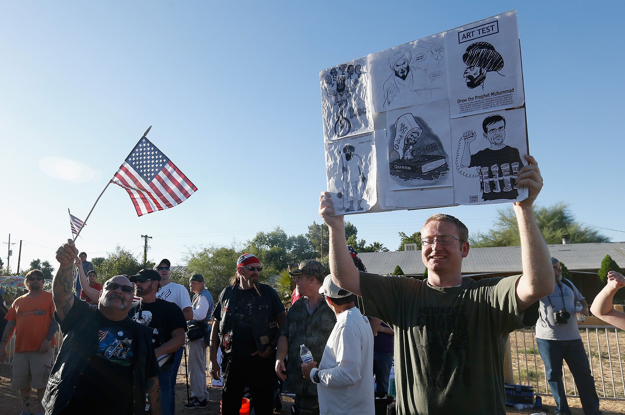 Protesters hold up political cartoons depicting Mohammed as they rally outside the Islamic Community Center