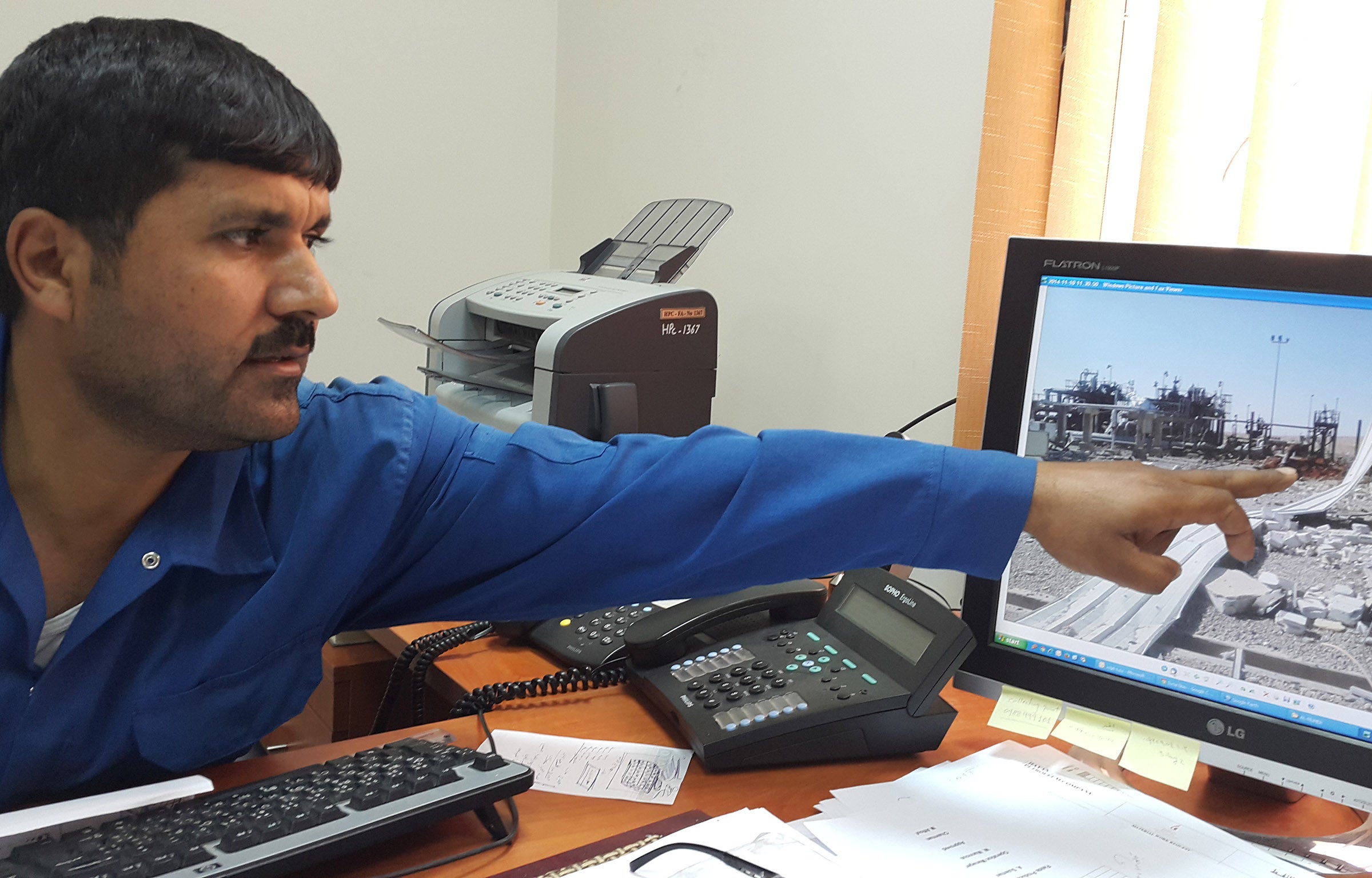 Director of the Hayan gas and oil processing plant, Assad Sulieman, shows the damage to oil fields