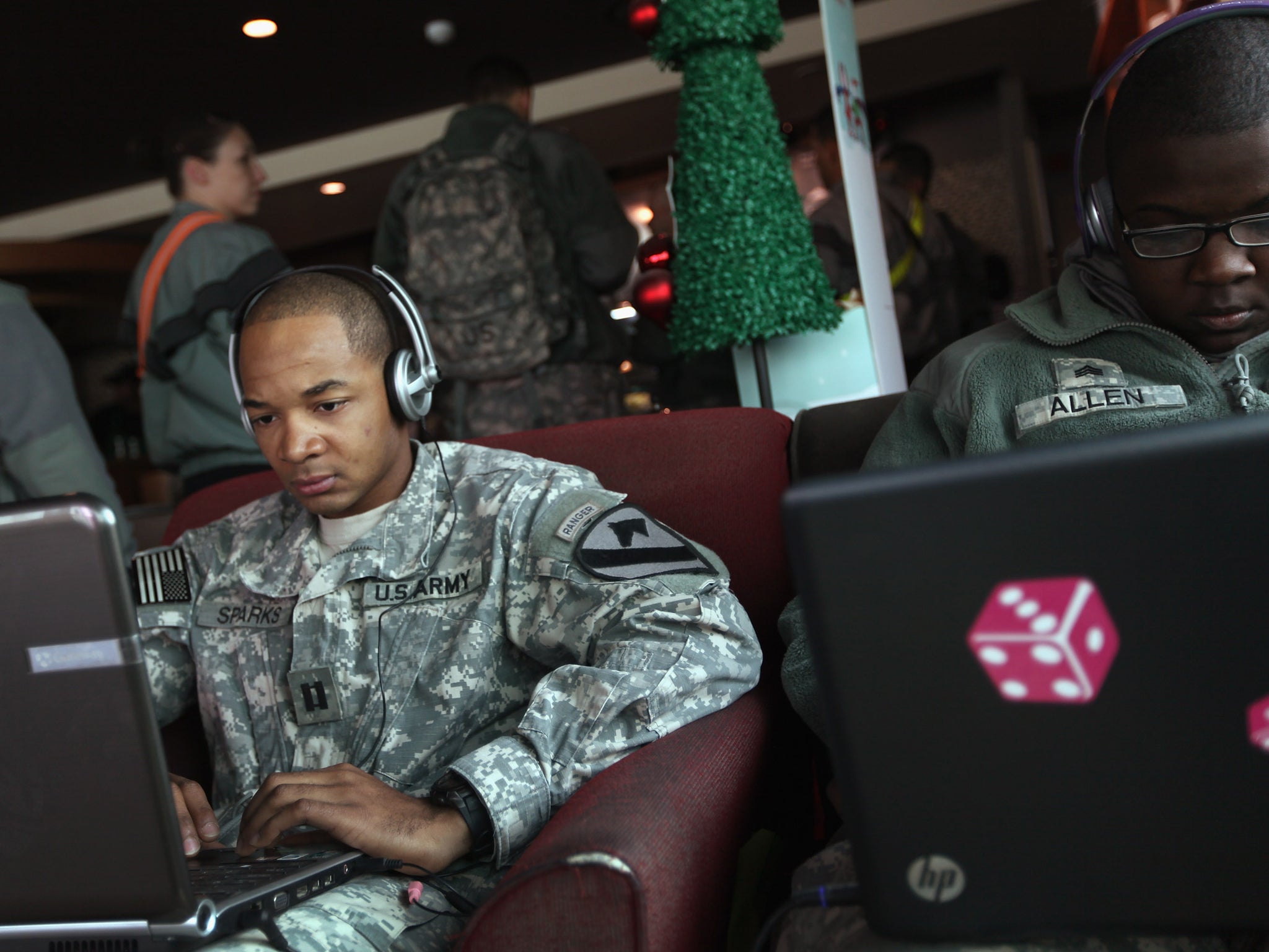 U.S. Army Captain Bishop Sparks shops for a car online as he sits in a Starbucks coffee shop while continuing to wait to leave Kuwait and head home after exiting from Iraq on December 11, 2011