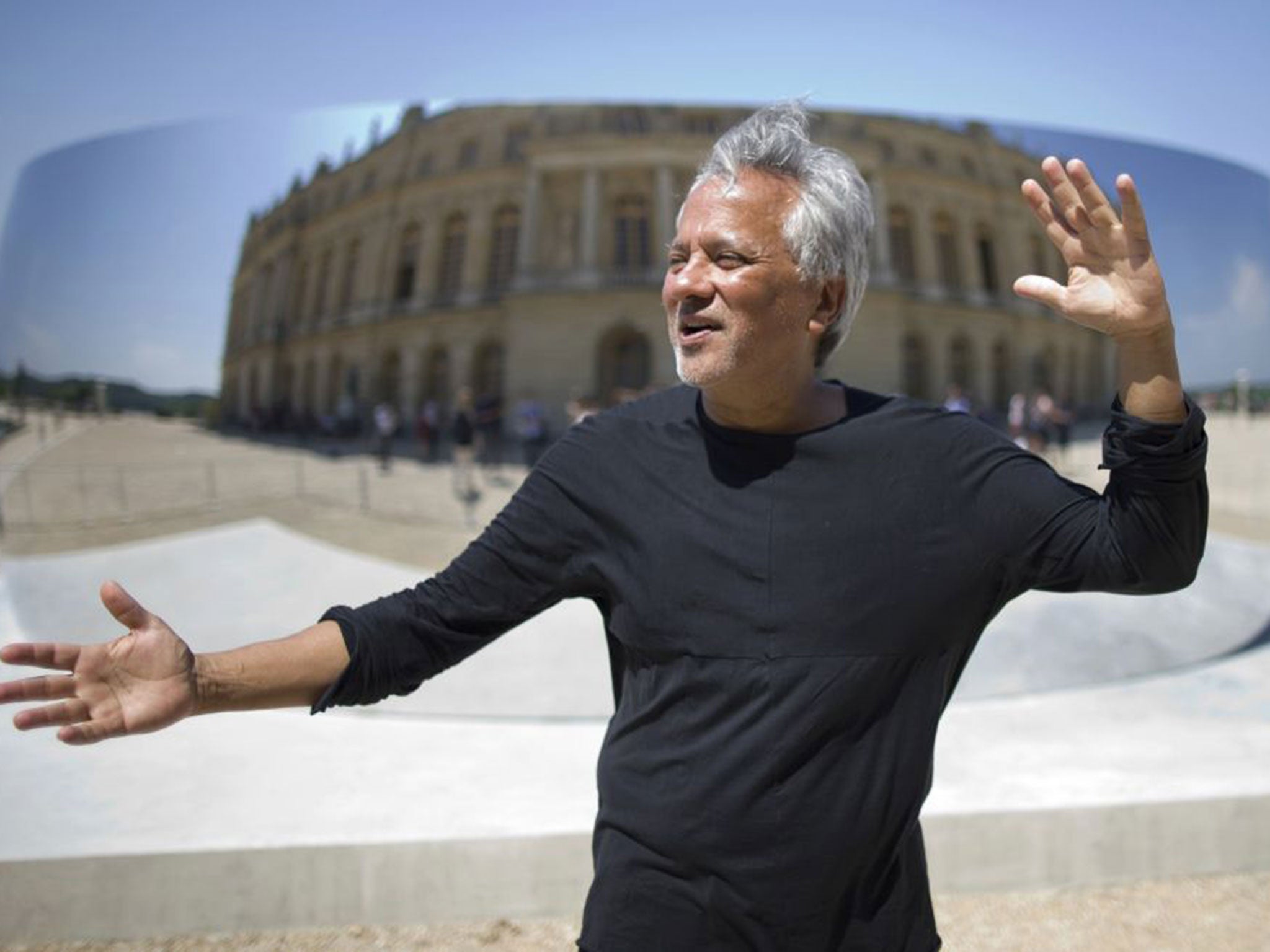 Indian-born British artist Anish Kapoor gestures as he speaks to journalists in front of his work "C-Curve"