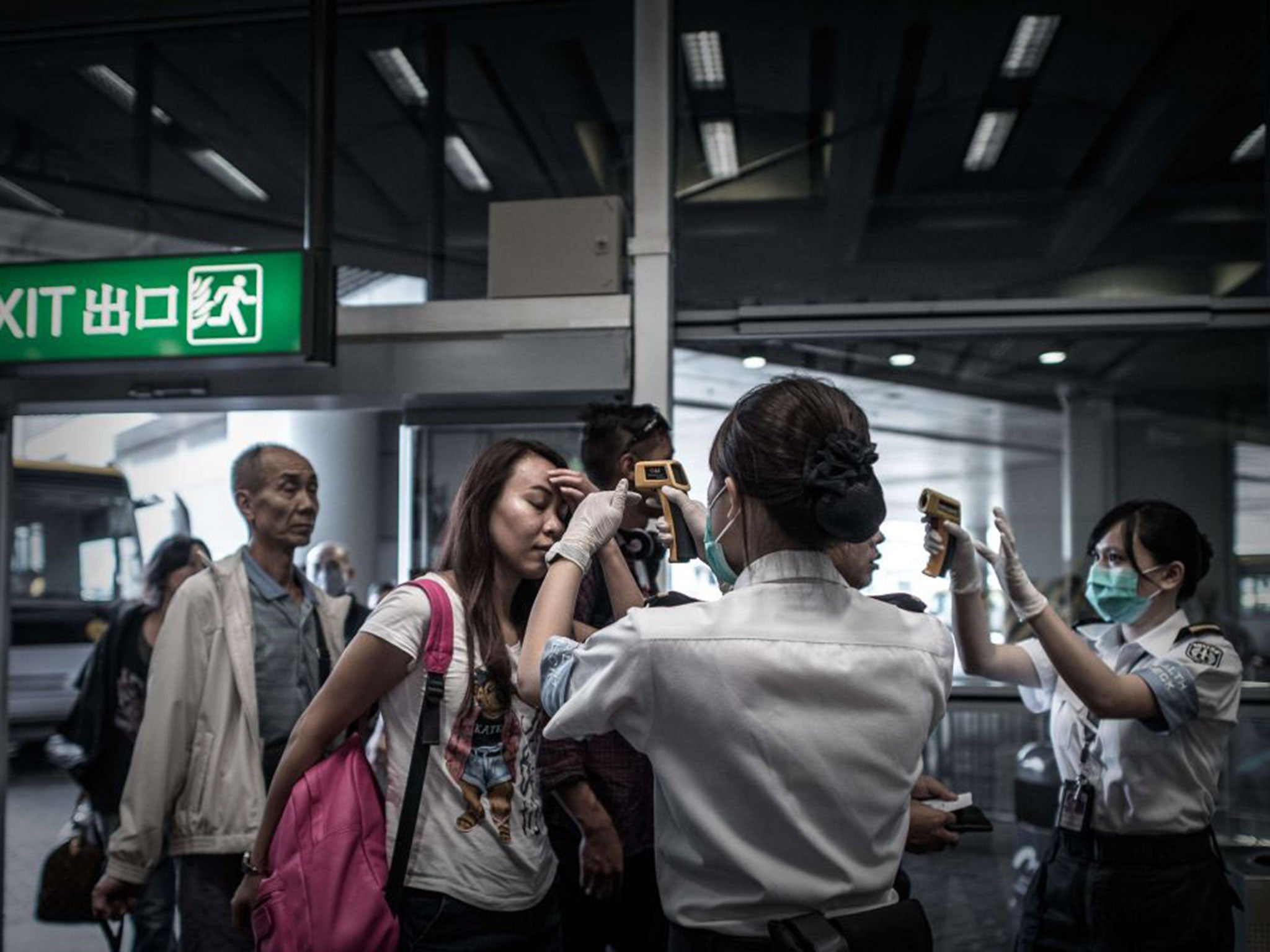 Passengers get their temperature checked as part of preventive measures against the spread of Middle East Respiratory Syndrome (MERS)