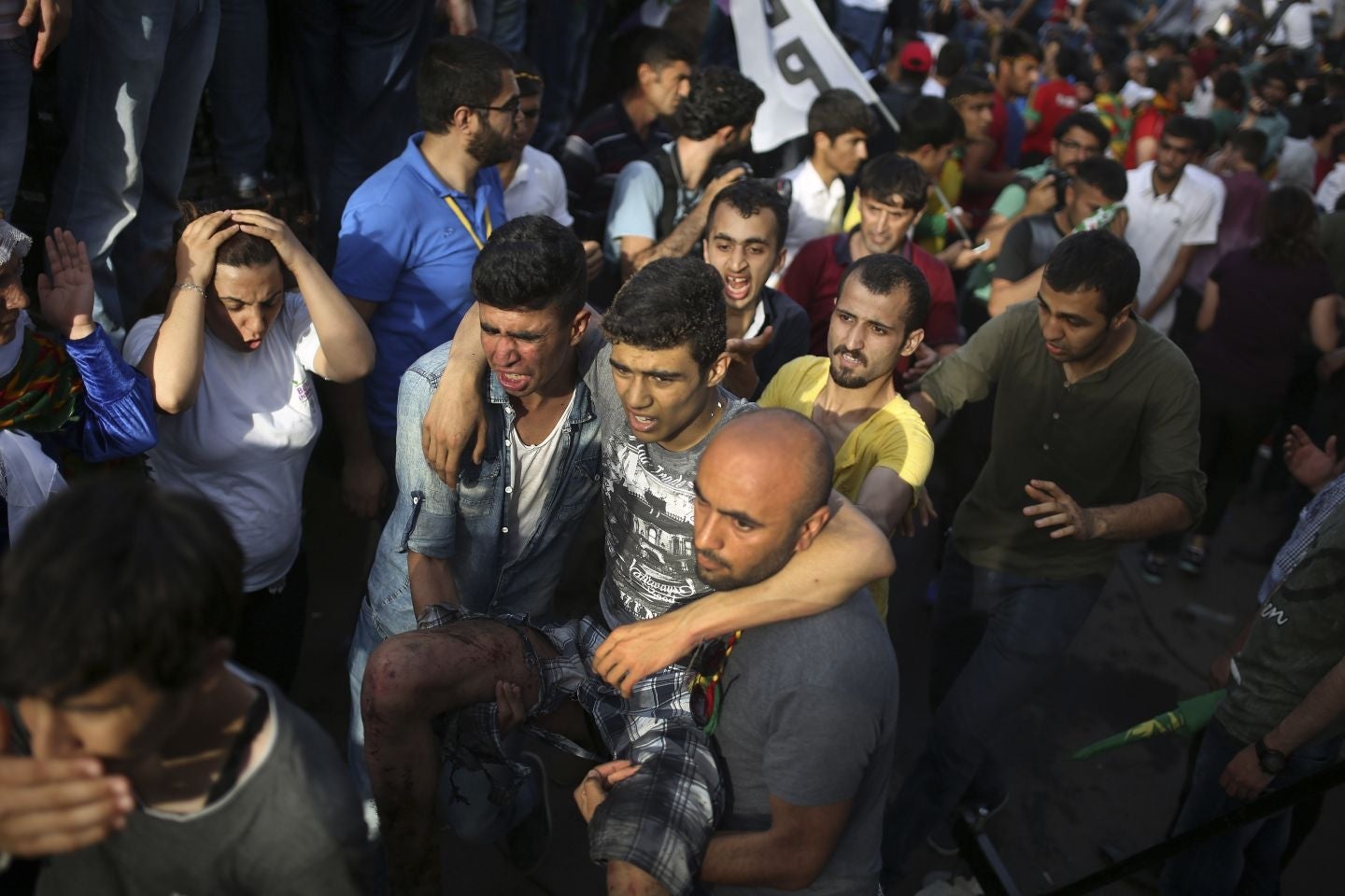 A youth is helped after being wounded in an explosion at a pro-Kurdish Peopleís Democratic Party (DHP) rally in Diyarbakir, southeastern Turkey, Friday, June 5, 2015 ahead of the general election on June 7, 2015. Two blasts occurred five minutes apart at