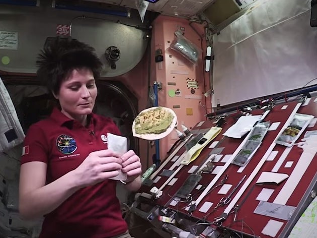 ESA astronaut, Samantha Cristoforetti prepares a meal on ISS