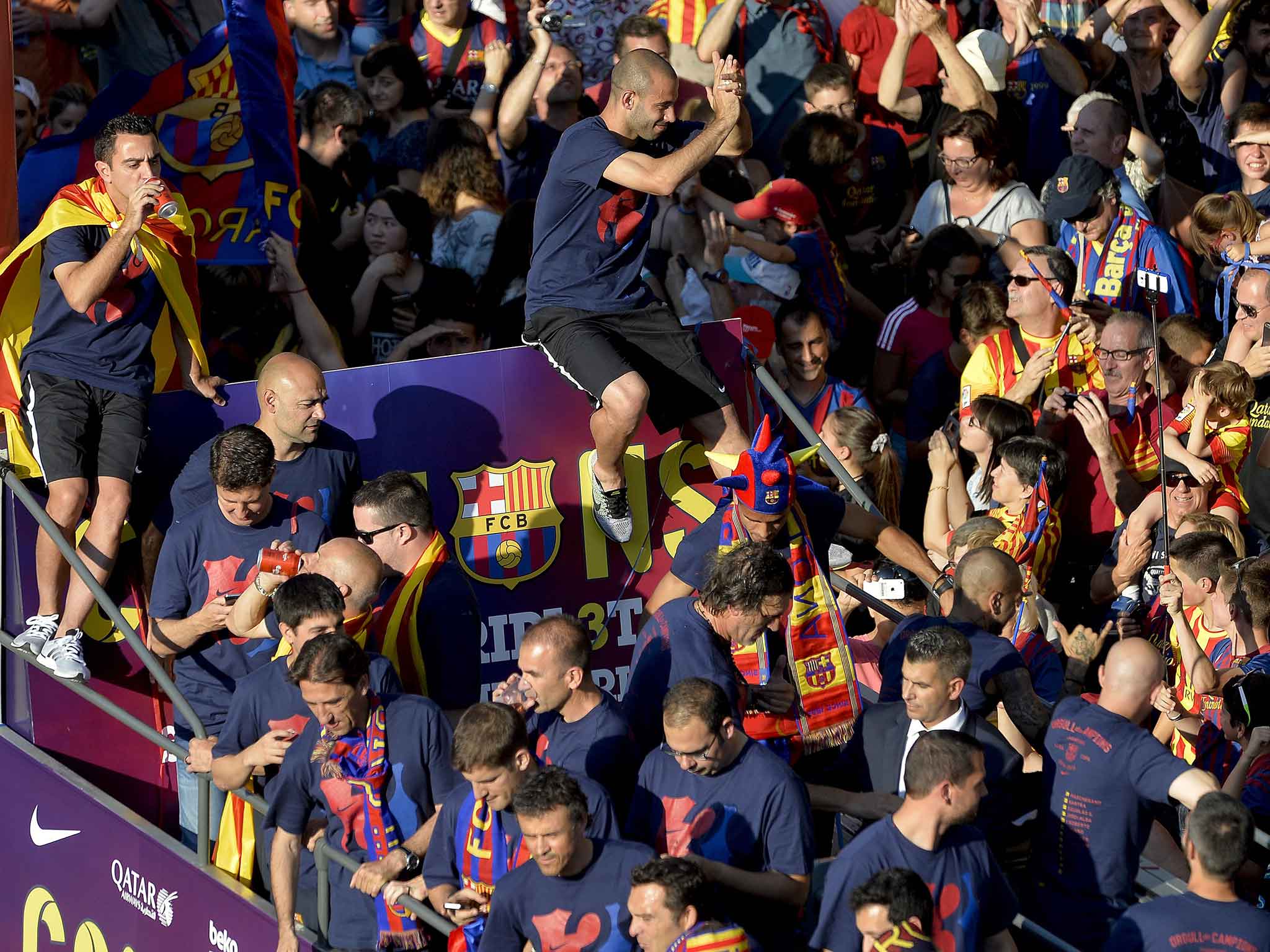 Xavi enjoys a drink during the open-top bus parade