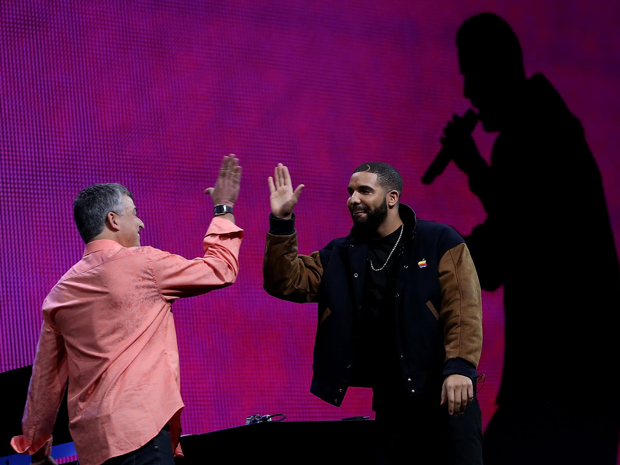 Apple's senior vice president of Internet Software and Services Eddy Cue (L) high fives with recording artist Drake during the Apple Music introduction at the Apple WWDC on June 8, 2015 in San Francisco, California