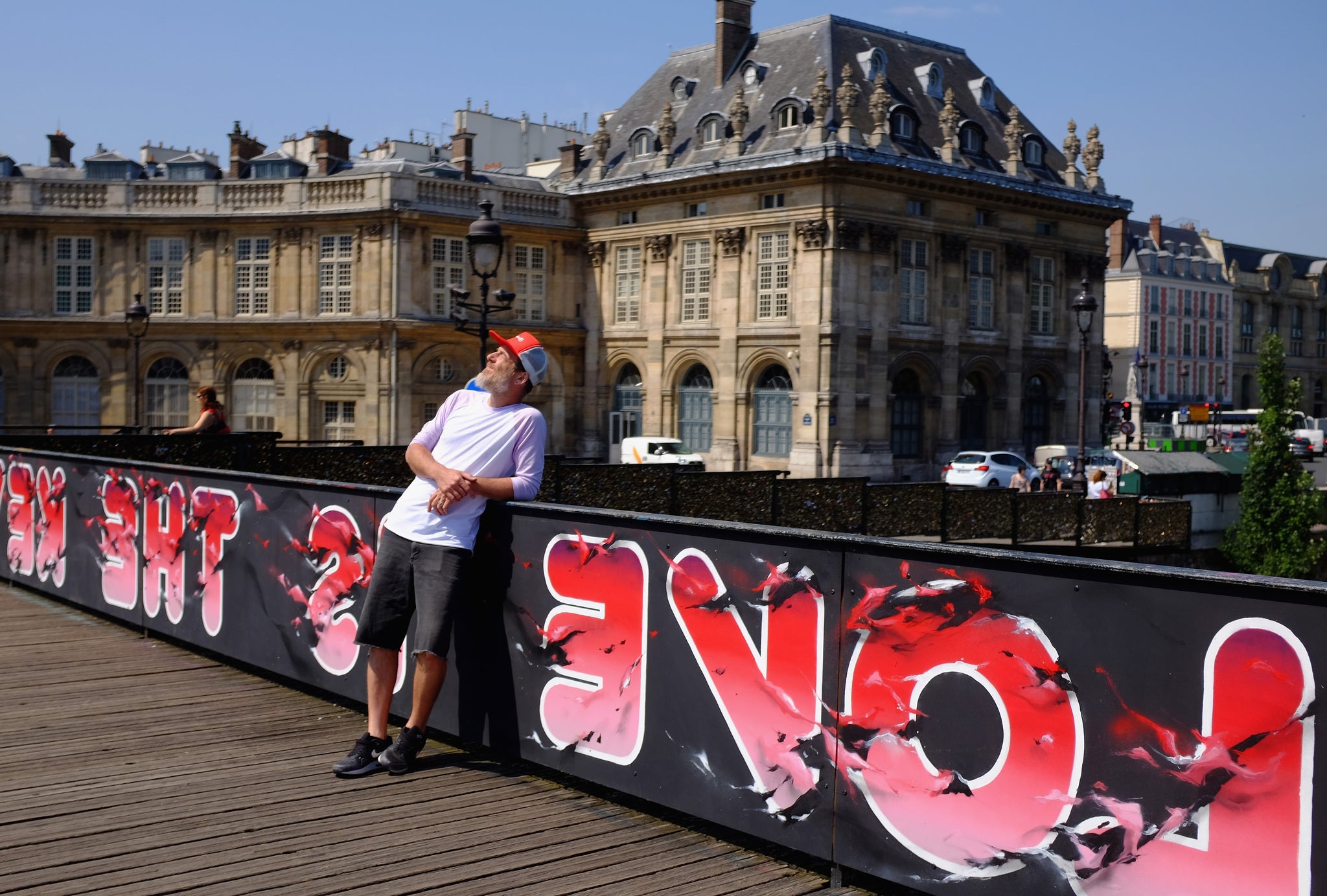 One of the street artists poses in front of his work 'Love is the key' (Photo by Pascal Le Segretain/Getty Images)