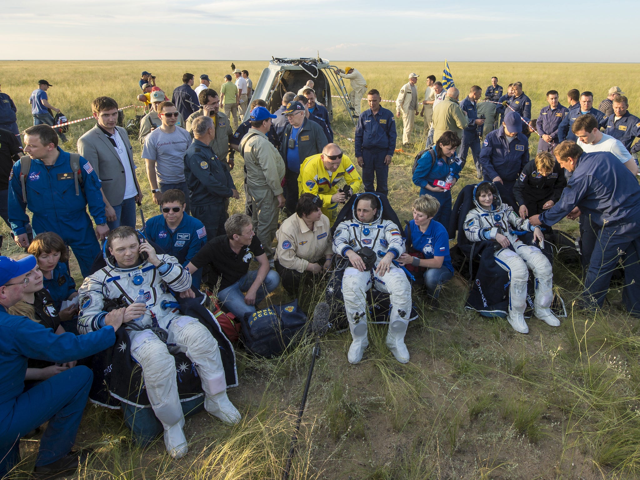 International Space Station crew members (L-R) Terry Virts of the U.S., Anton Shkaplerov of Russia and Samantha Cristoforetti of Italy rest shortly after landing near the town of Zhezkazgan, Kazakhstan, June 11, 2015