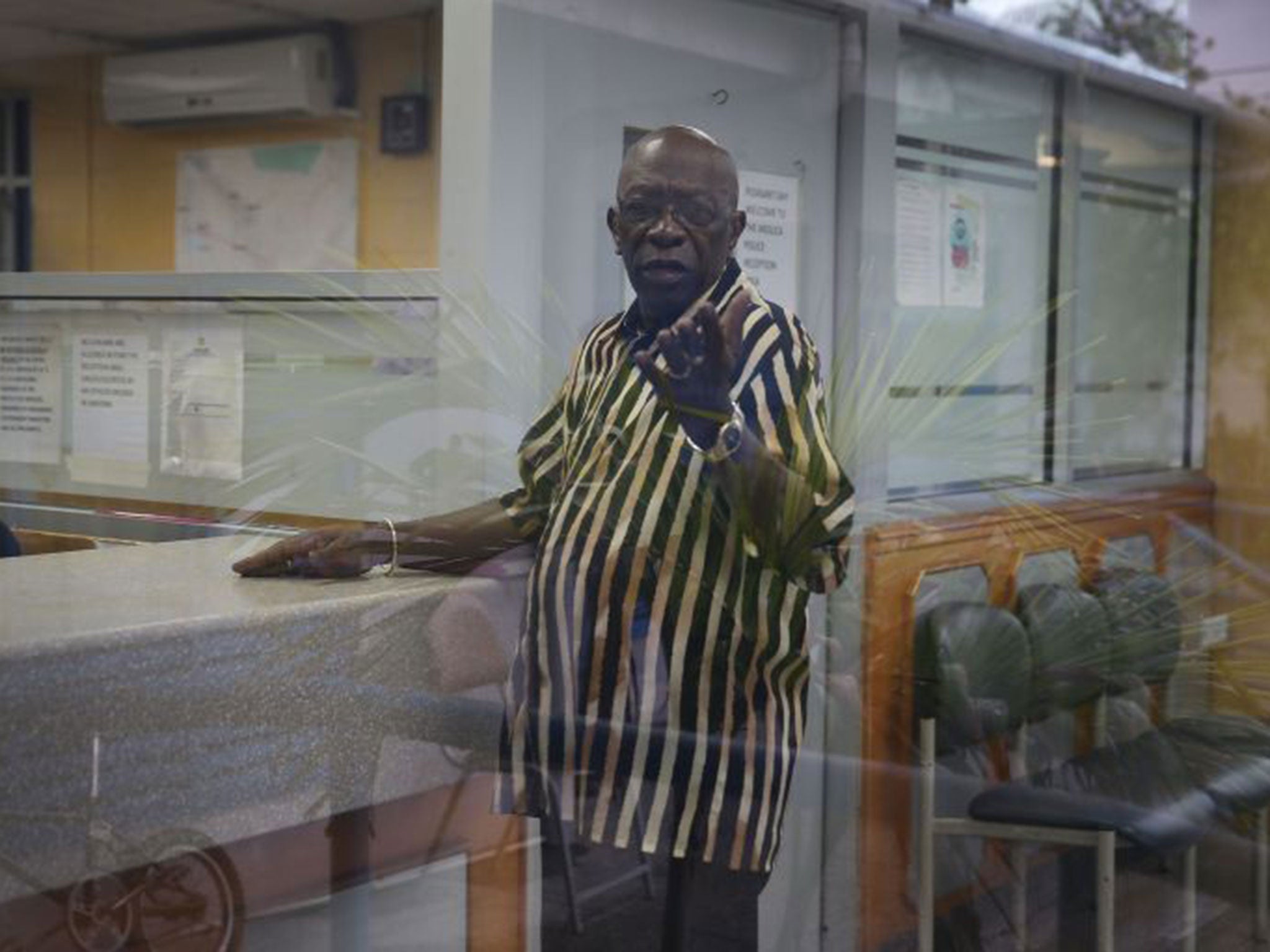 Former Fifa vice-president Jack Warner reacts to being photographed as he waits to sign in at the front desk of the Arouca Police Station as required under his bail agreement on 11 June, 2015 in Arouca, Trinidad And Tobago.