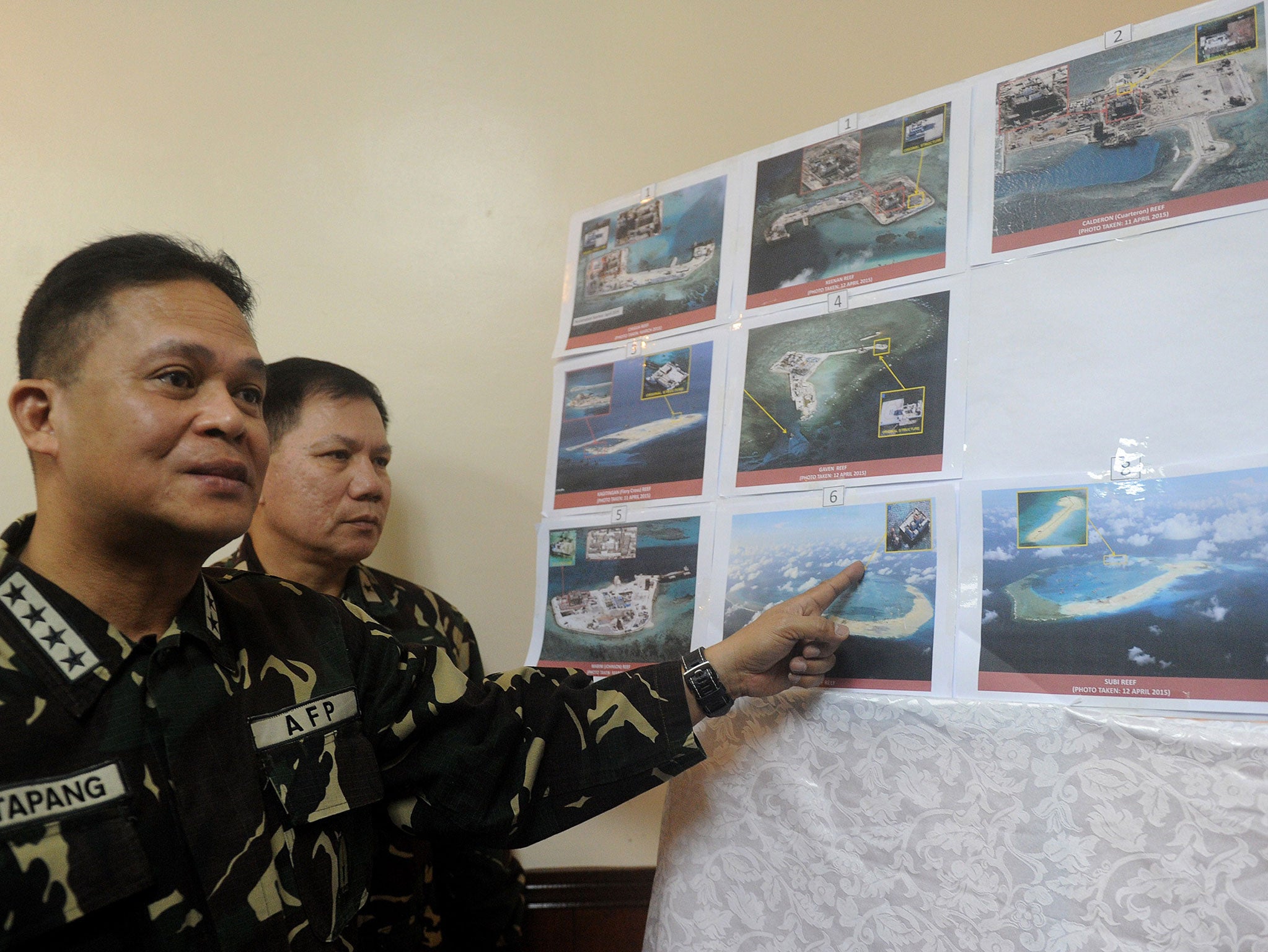 Filipino military chief General Gregorio Catapang points to aerial photos of Chinese construction over reefs and shoals in the Spratly archipelago during a press briefing in Manila on April 20, 2015