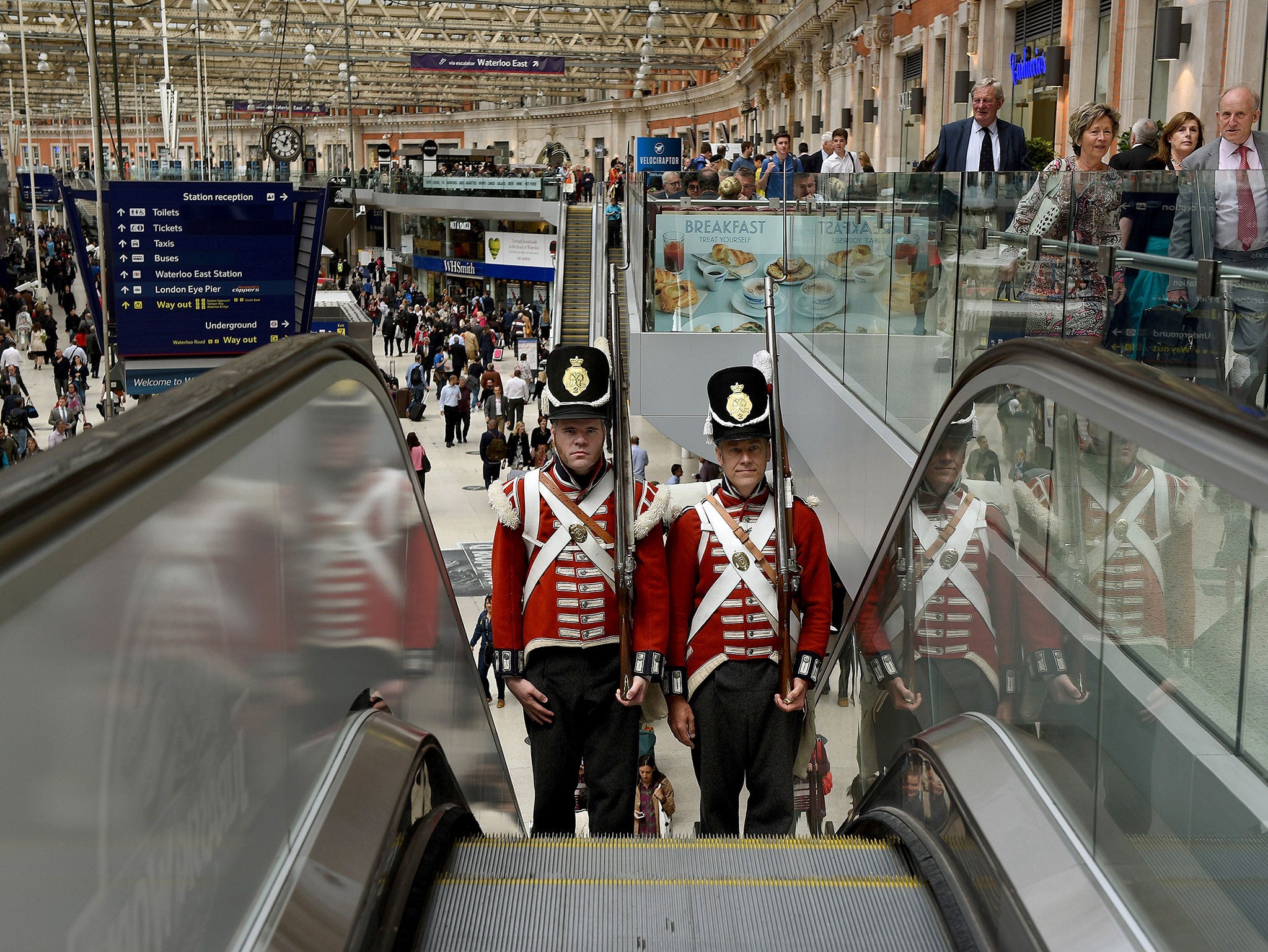 Two Battle of Waterloo reenactors travel up the escalators at Waterloo Station