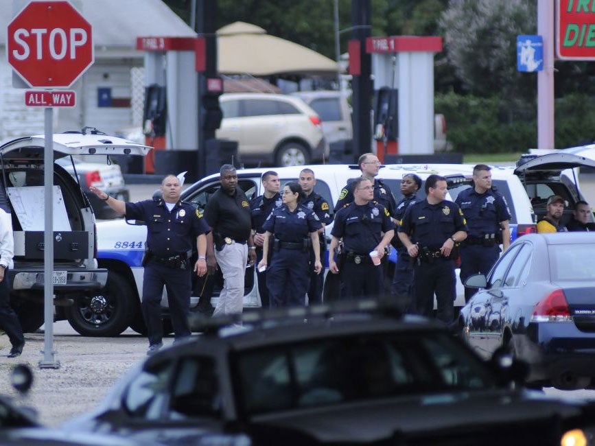 Dallas Police officers gather at Dowdy Ferry Road and Interstate 45 in Hutchins during a standoff. A suspect in the attack of the Dallas Police Headquarters believed to be James Boulware was shot by a Dallas Police sniper in the car park of a restaurant i