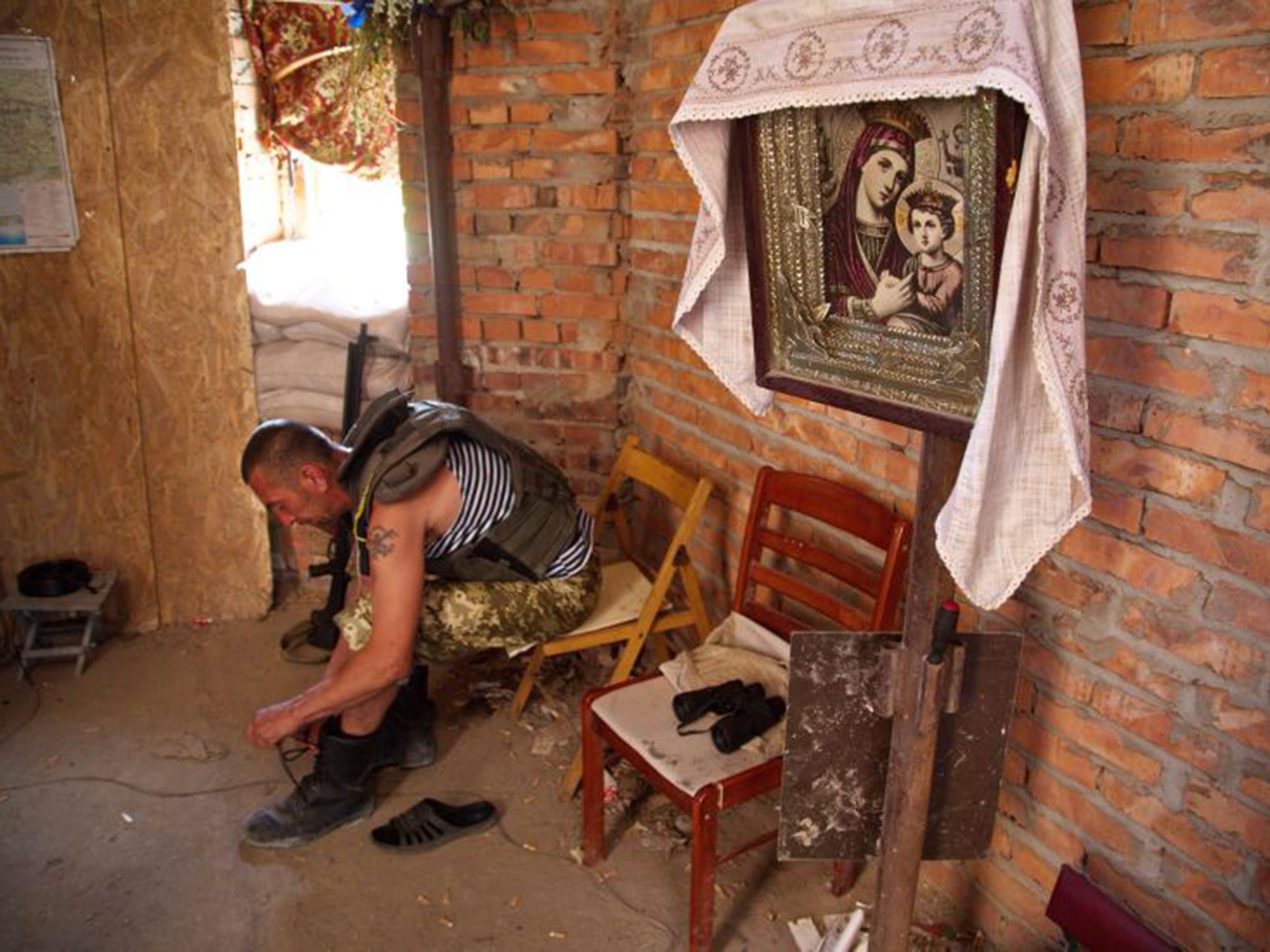 A Ukrainian serviceman takes shelter in a Pisky church