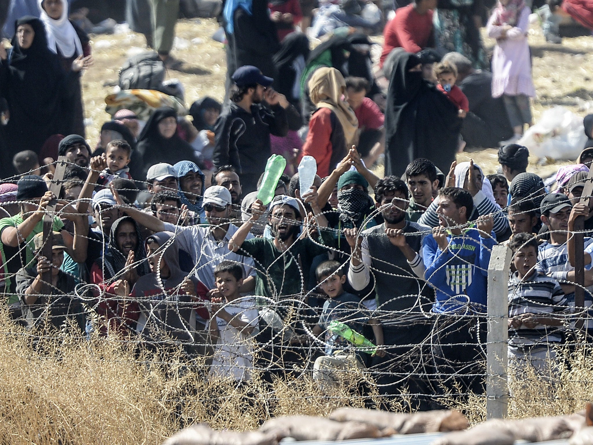 Turkish security forces used water cannon and fired warning shots to push Syrians back from the frontier as thousands massed at a border crossing to escape escalating fighting