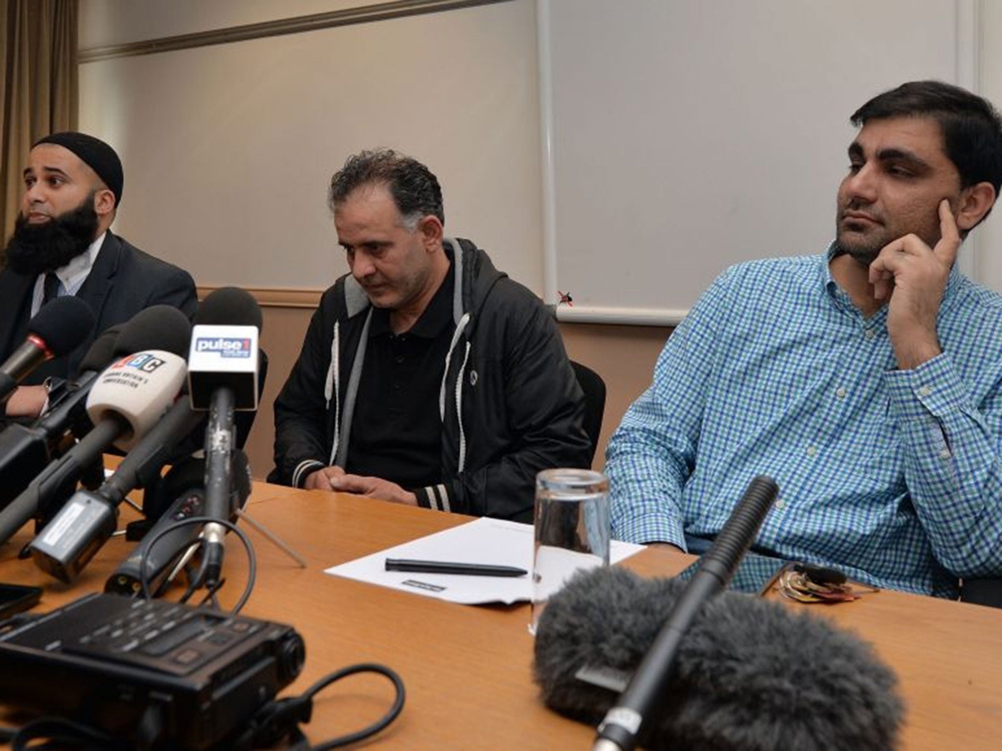 Akhtar Iqbal, husband of Sugra Dawood (C), and Mohammad Shoaib, husband of Khadija Dawood, (R) sit with their solicitor Balaal Khan during a news conference to appeal for the return of their missing wives and children, in Bradford, northern England, on June 16, 2015.