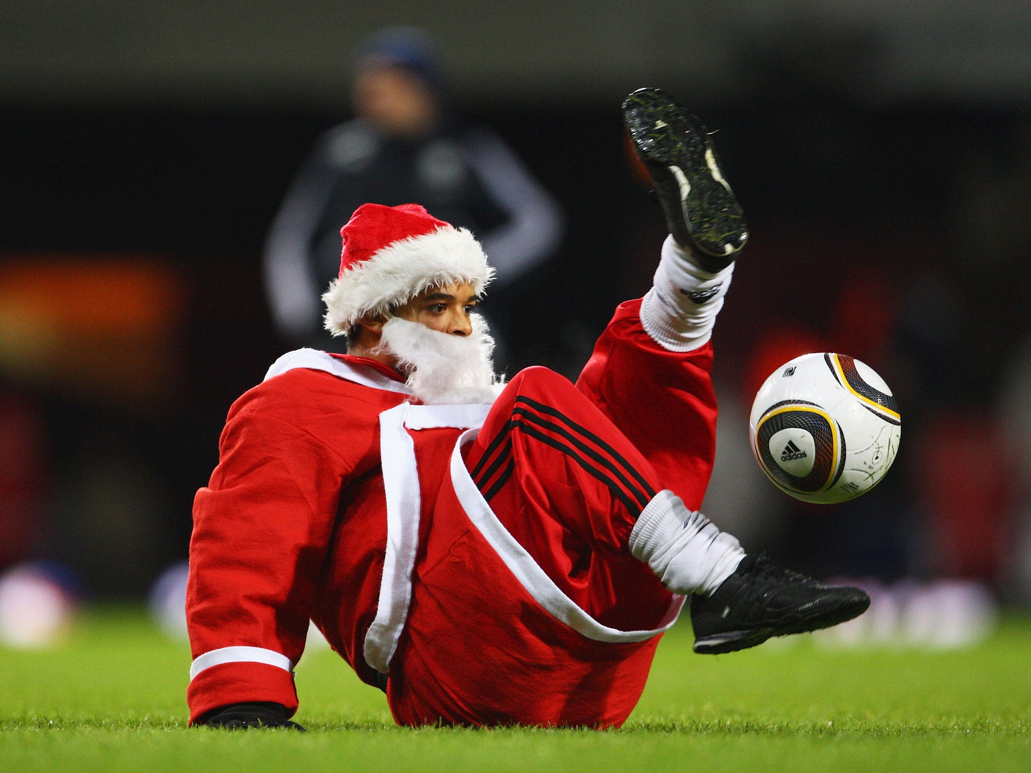 A football fans dressed as Father Christmas performs keepy-uppys