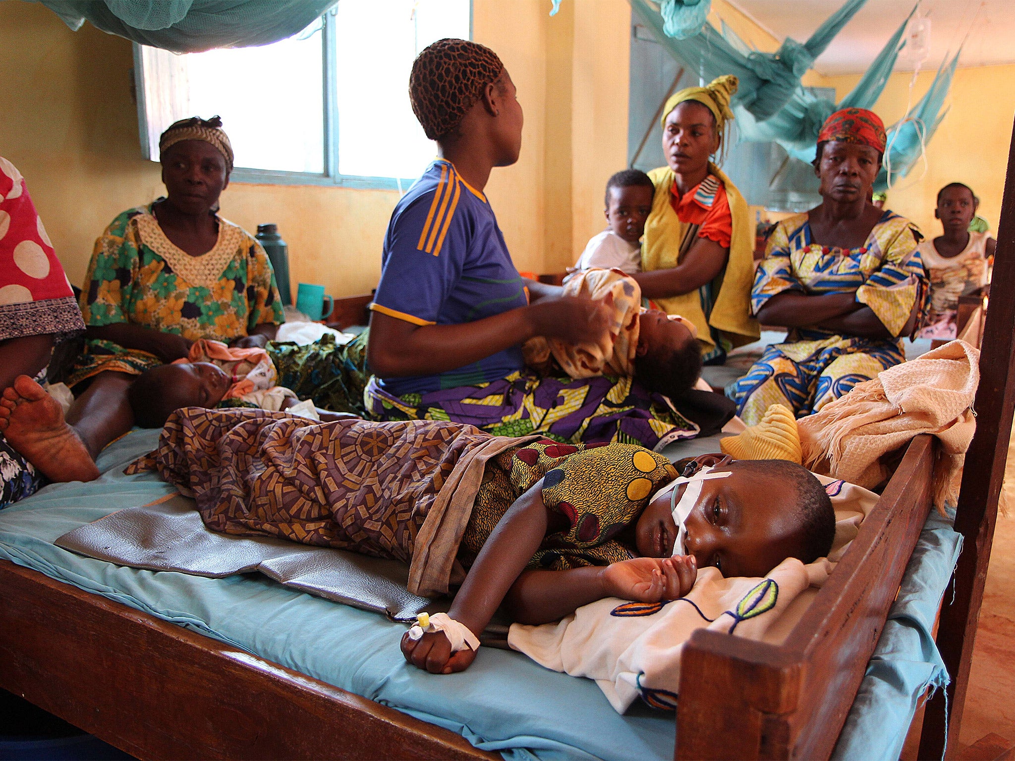 A child suffering from malaria lies on a hospital in Tanzania