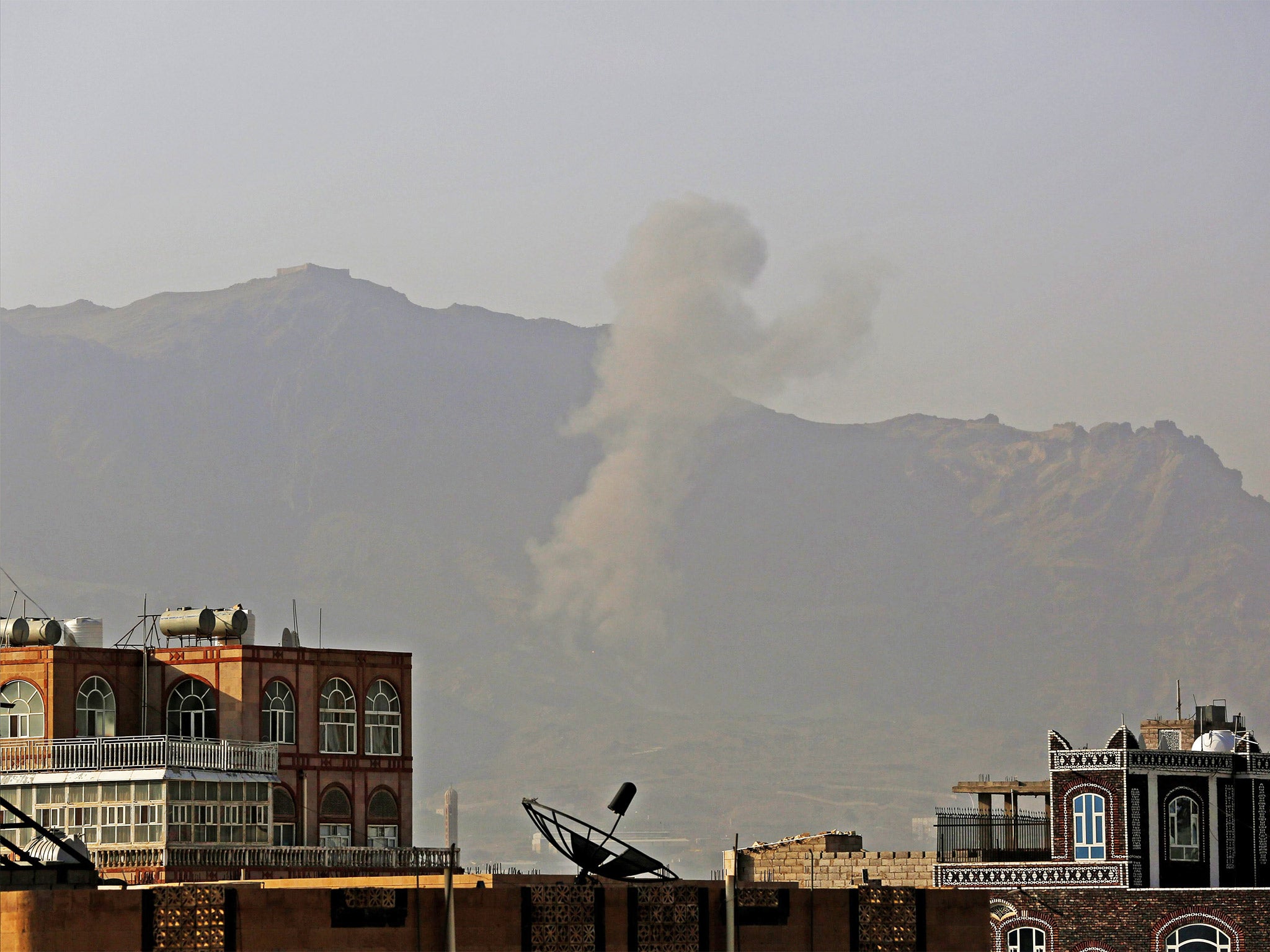 Smoke rises above buildings after an airstrike allegedly carried out by the Saudi-led coalition hit positions held by the Houthis in Sanaa