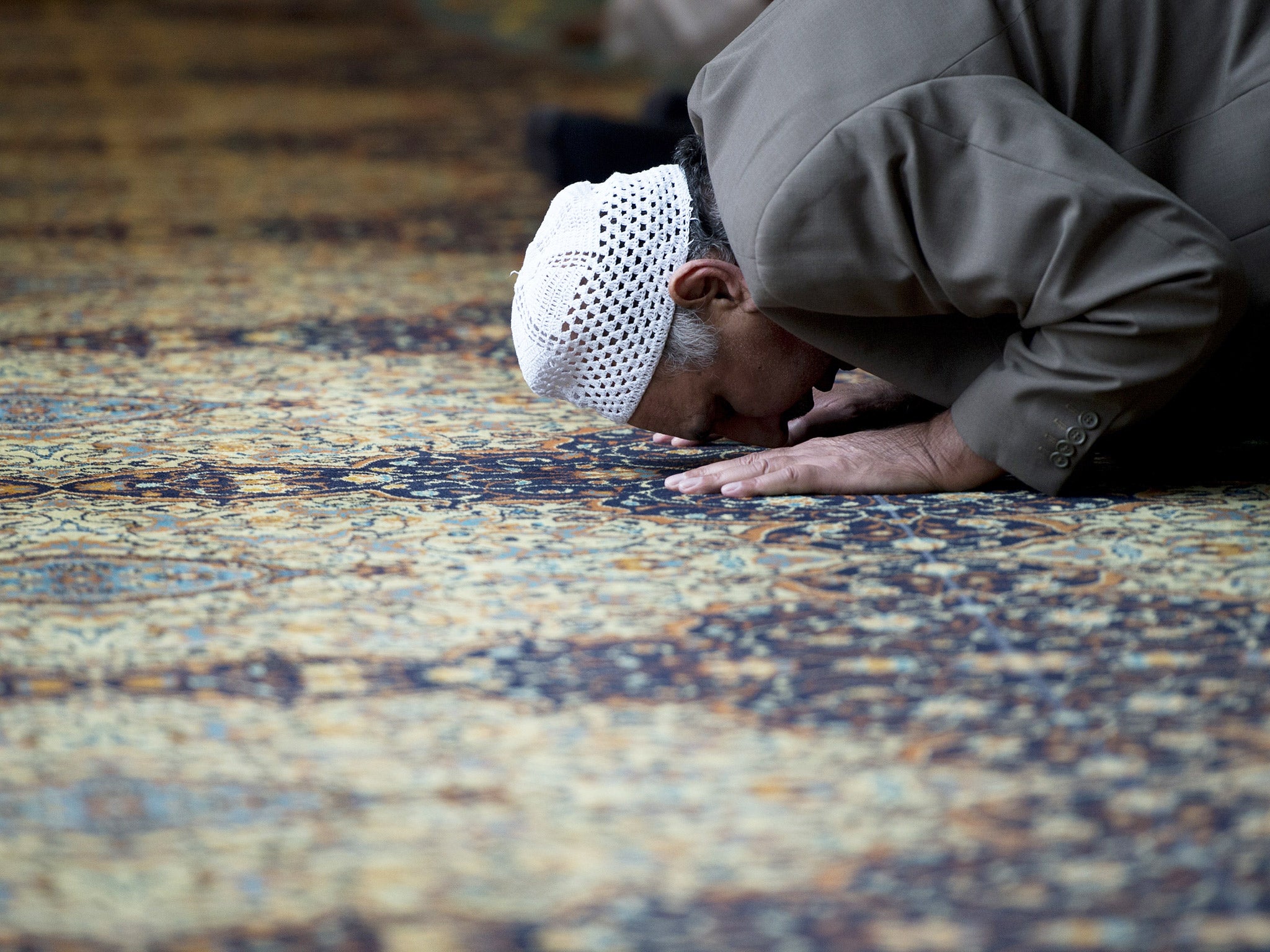 A muslim man prays at a mosque in Manchester