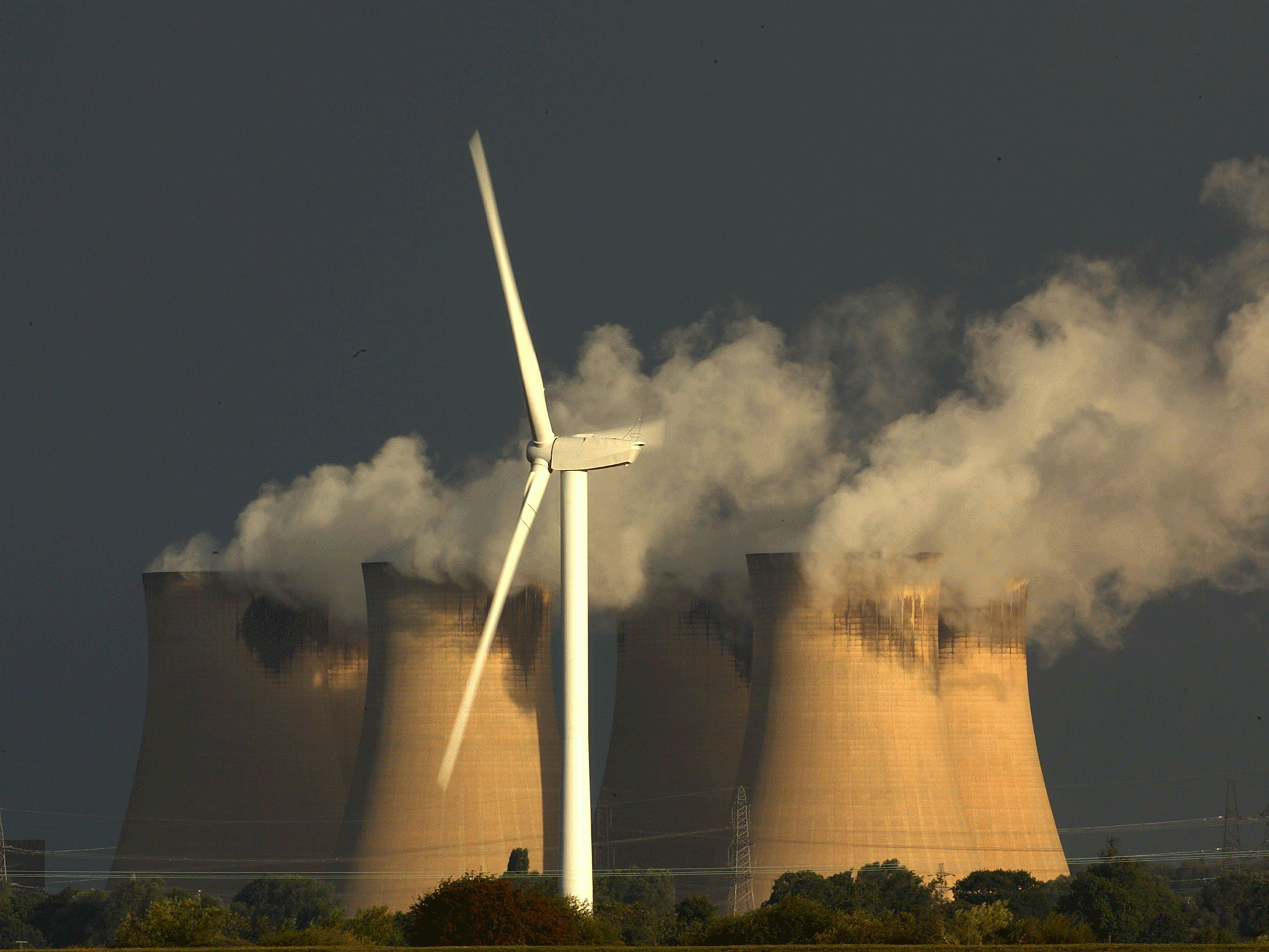 Wind turbines generate electricity in the shadow of Drax coal-fired power station on August 24, 2010 in Selby, England