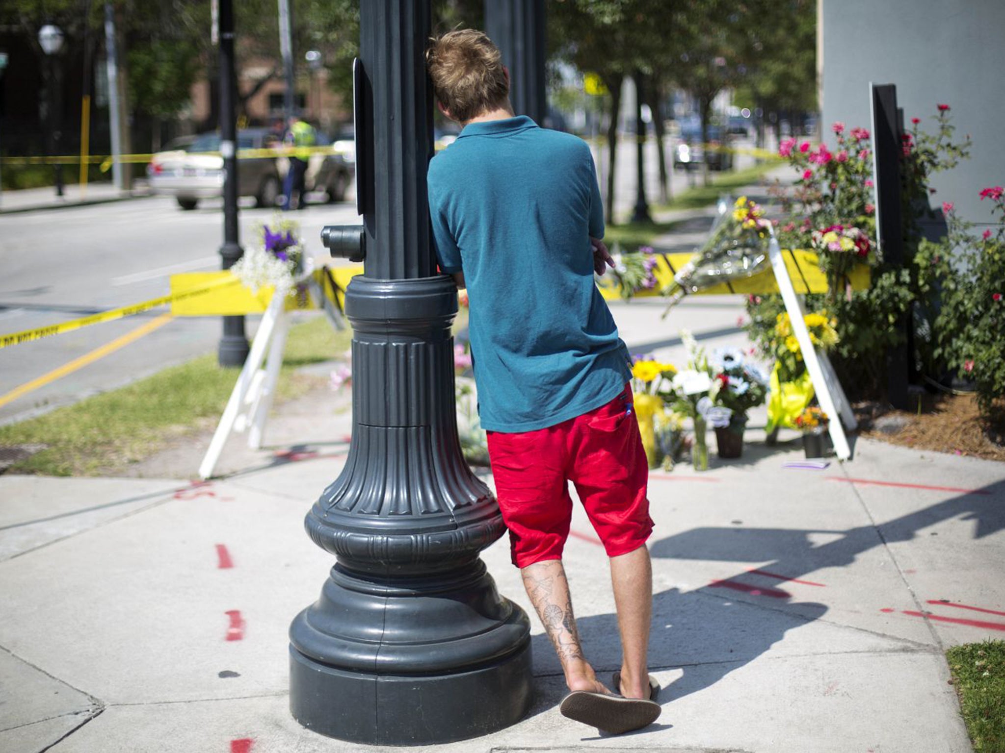 A visitor contemplates floral tributes close to the church where a white man shot dead nine black people at a Bible study class