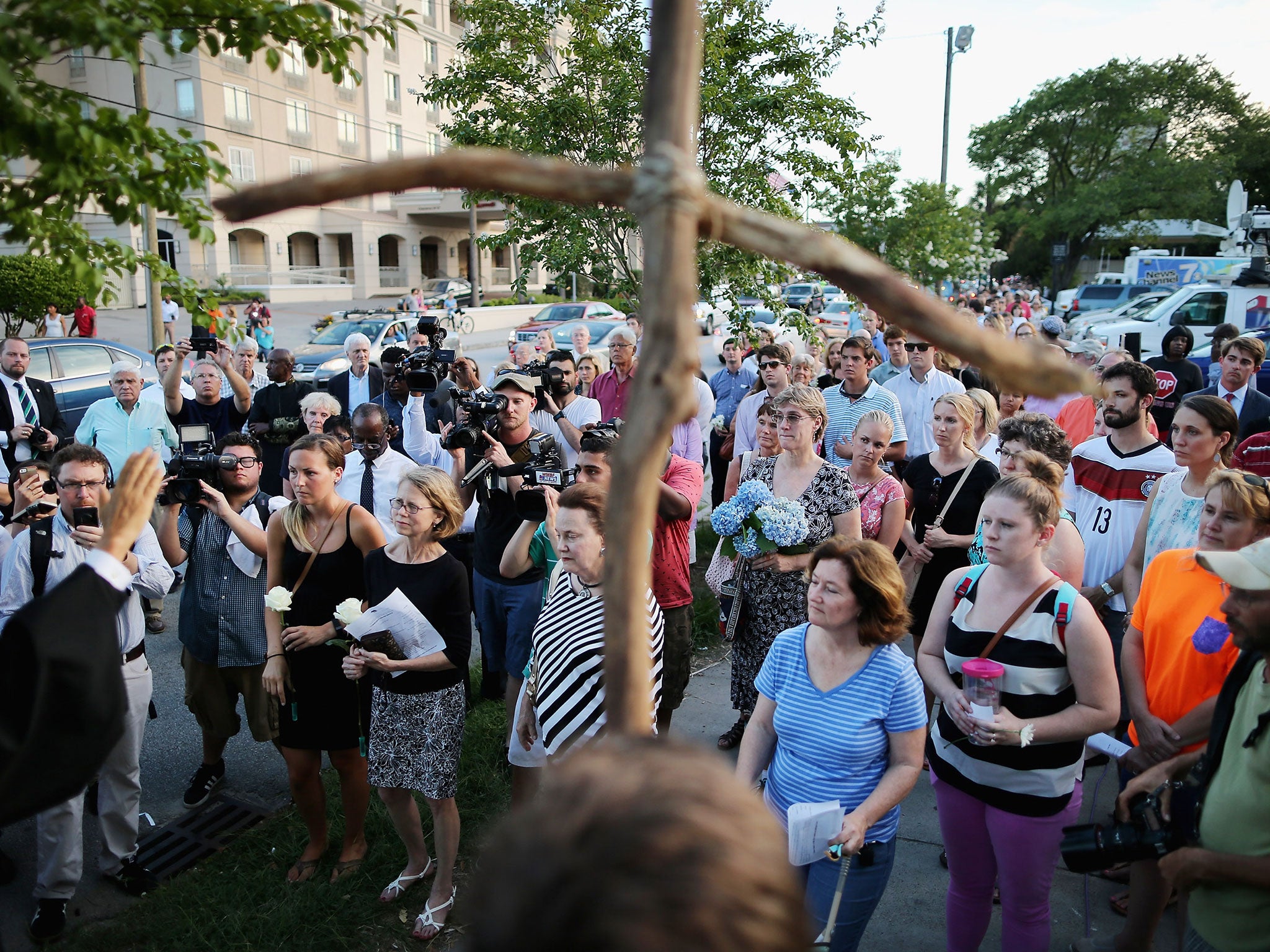 Mourners pray and lay flowers during a community service for victims of the shooting at the Emanuel African Methodist Episcopal Church