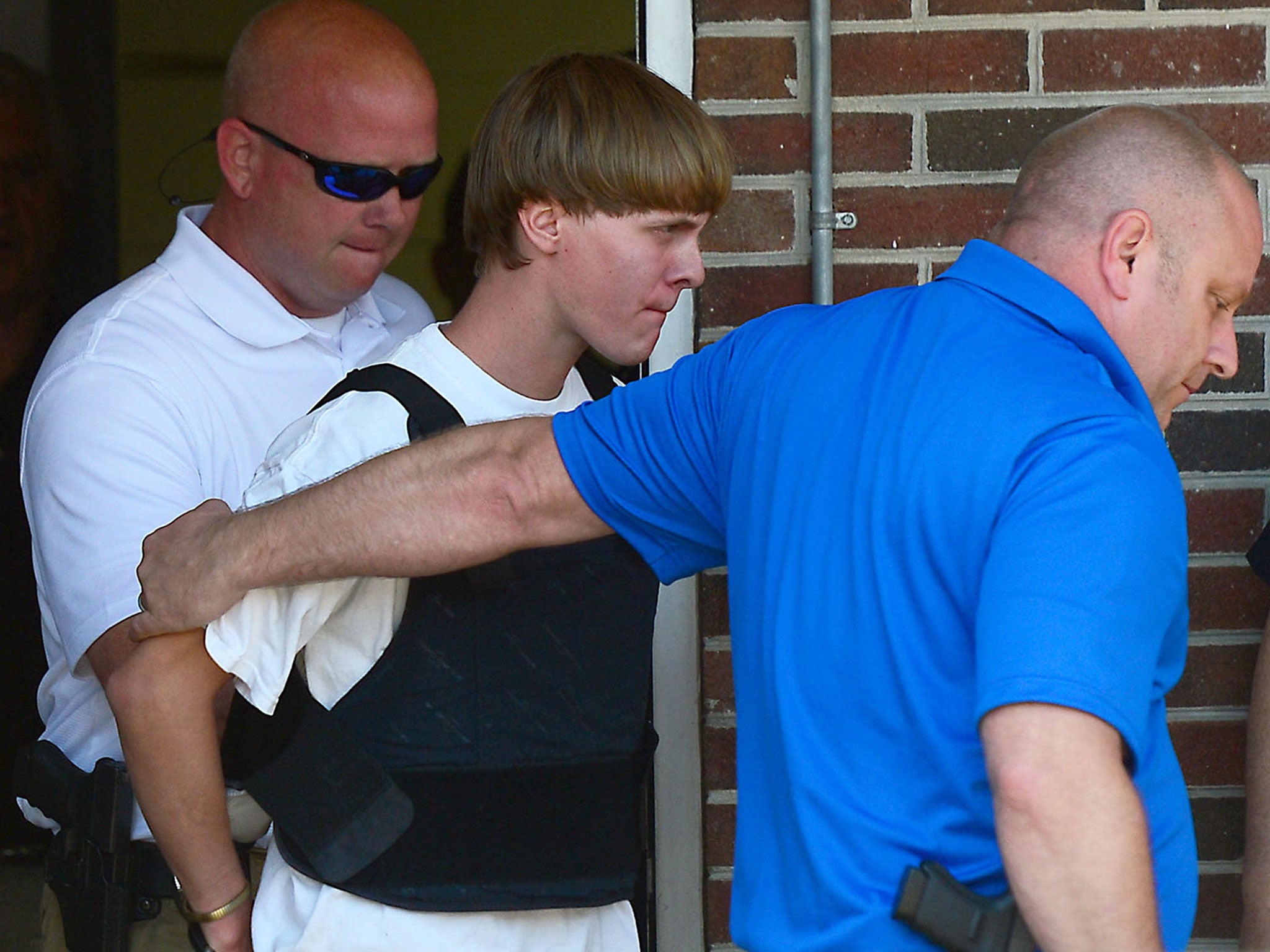Charleston shooting suspect Dylann Roof is escorted from the Shelby Police Department