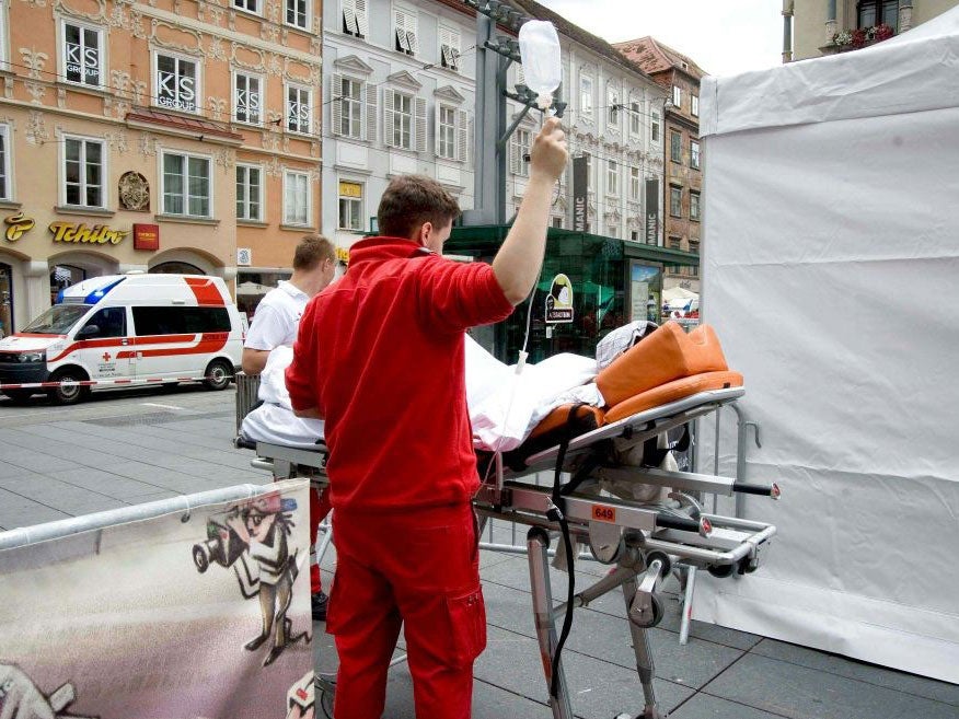 Paramedics treat a person at the scene where an SUV drove into pedestrians in the city center of Graz, Austria