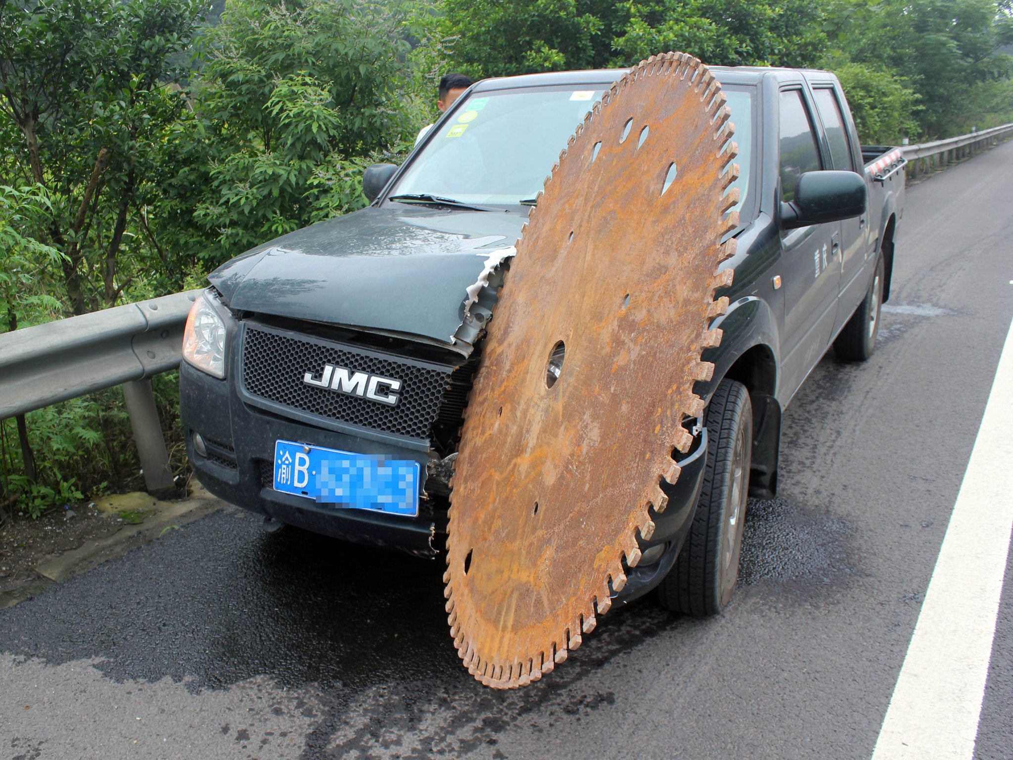 The car was left was a saw blade stuck in the bonnet in Chongqing, China. Photo: Rex Features