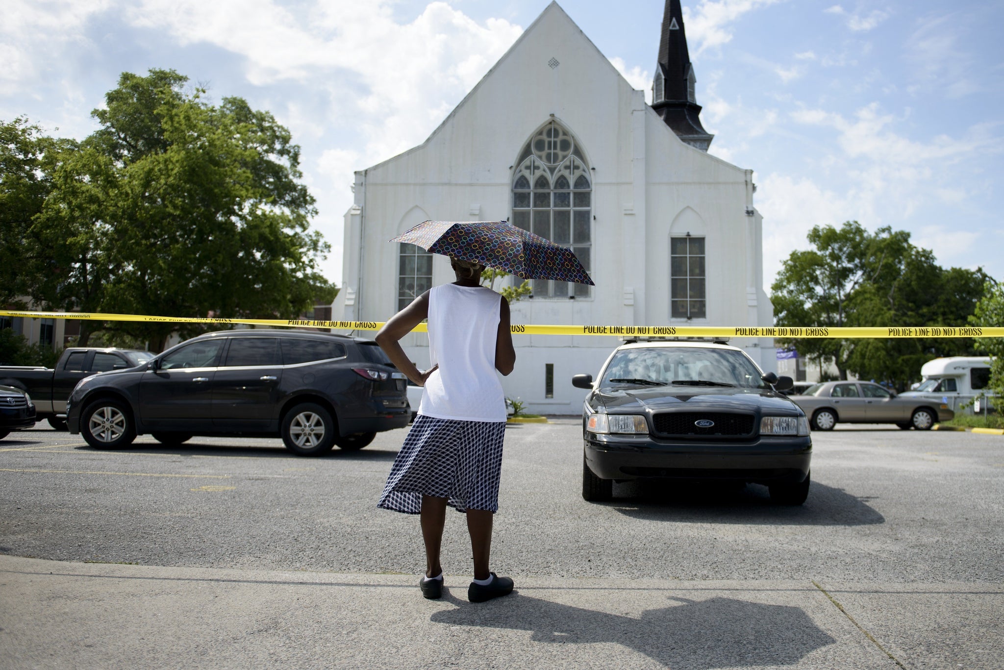 A parishioner looks toward police vehicles and shooting victims cars outside Emanuel AME Church in Charleston, South Carolina