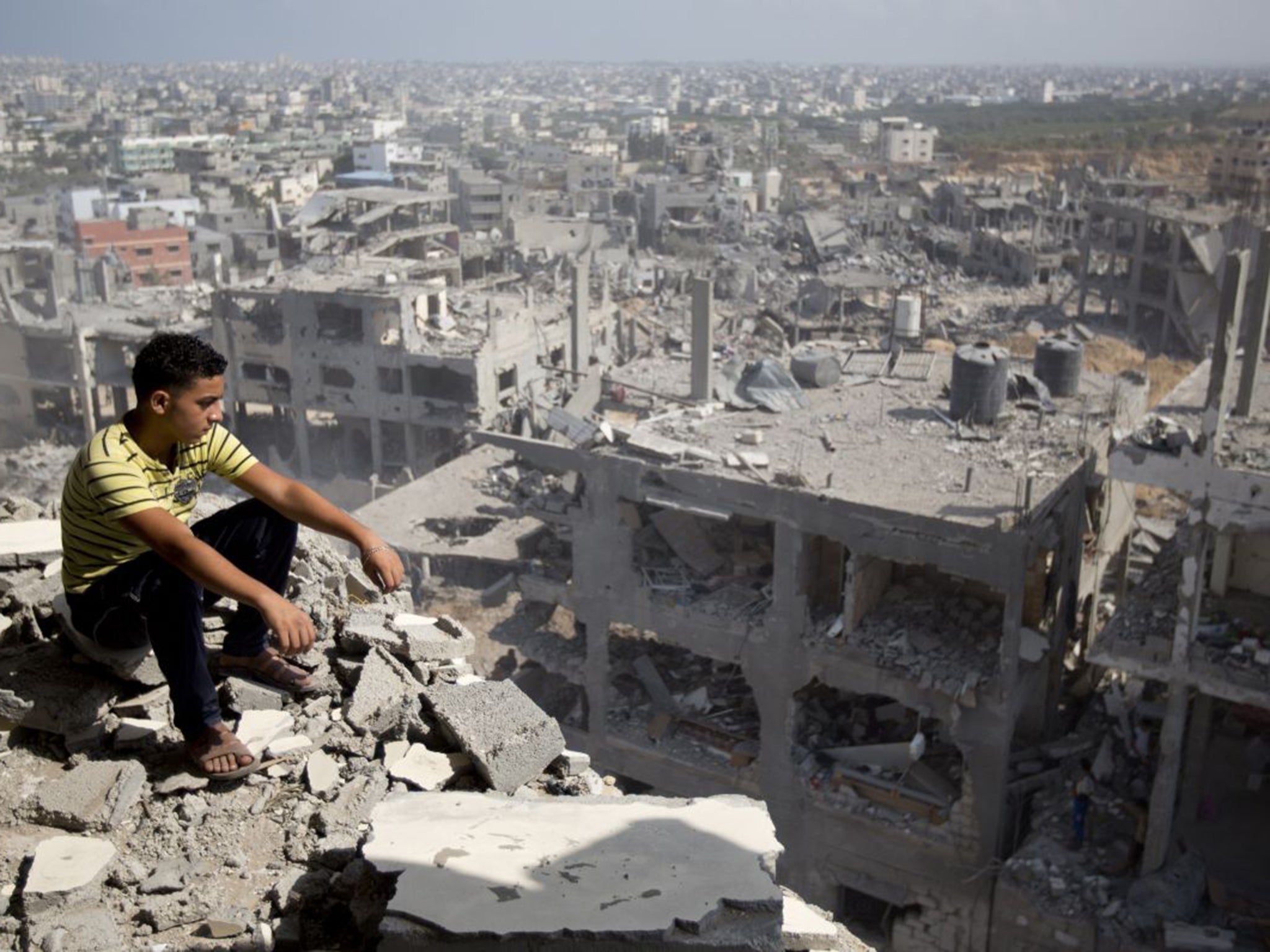 A Palestinian looks over destruction in Gaza City as a fragile ceasefire entered a second day