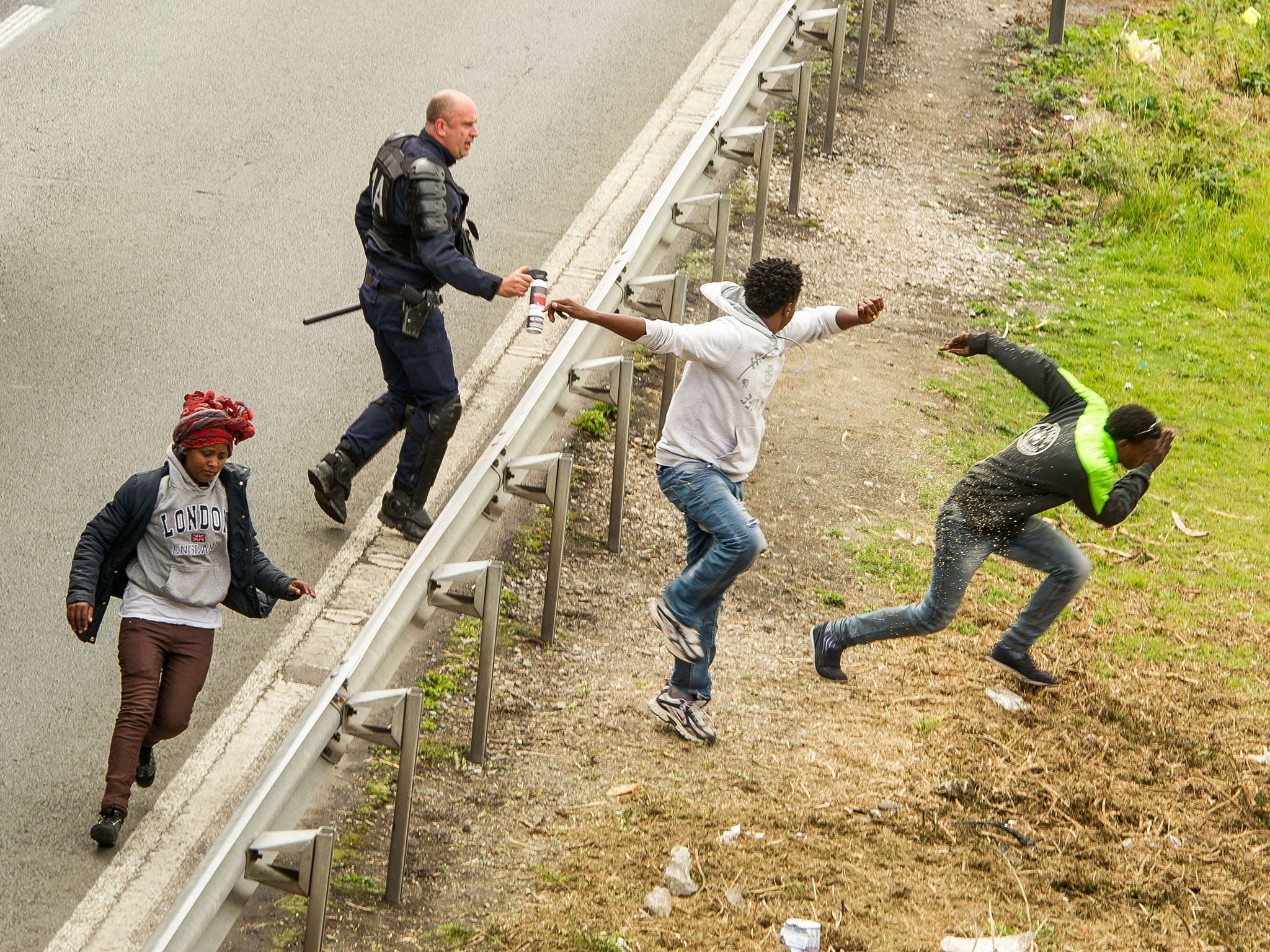 A police officer sprays tear gas to migrants