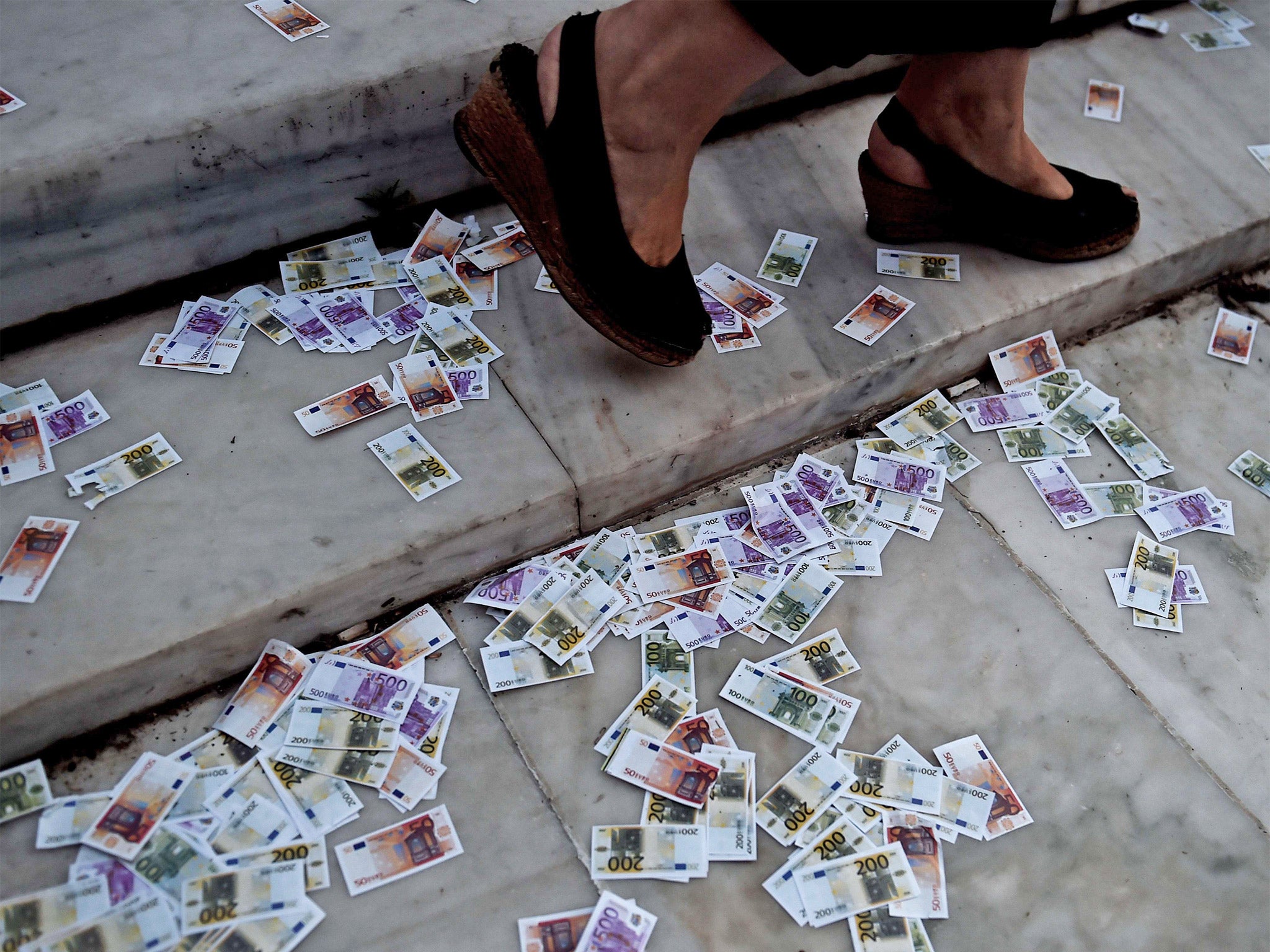 Fake euro notes litter the ground during a pro-European demonstration in front of the Greek parliament in Athens on Tuesday (Getty)