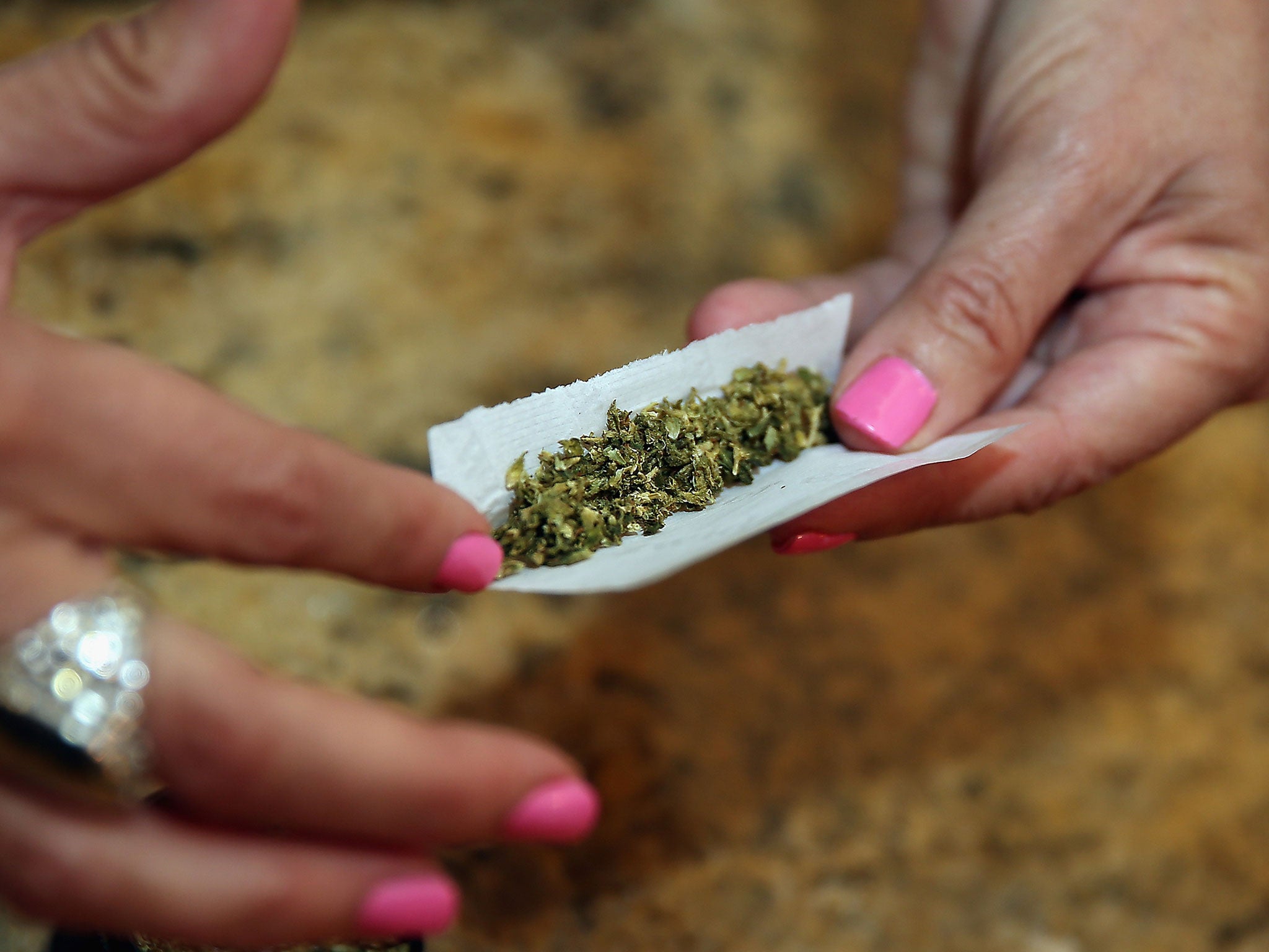 A woman rolls a spliff