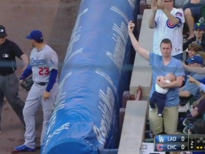 Keith Hartley, a Chicago Cubs fan stole the catch from the opposition player, while bottle-feeding his seven-month old son.