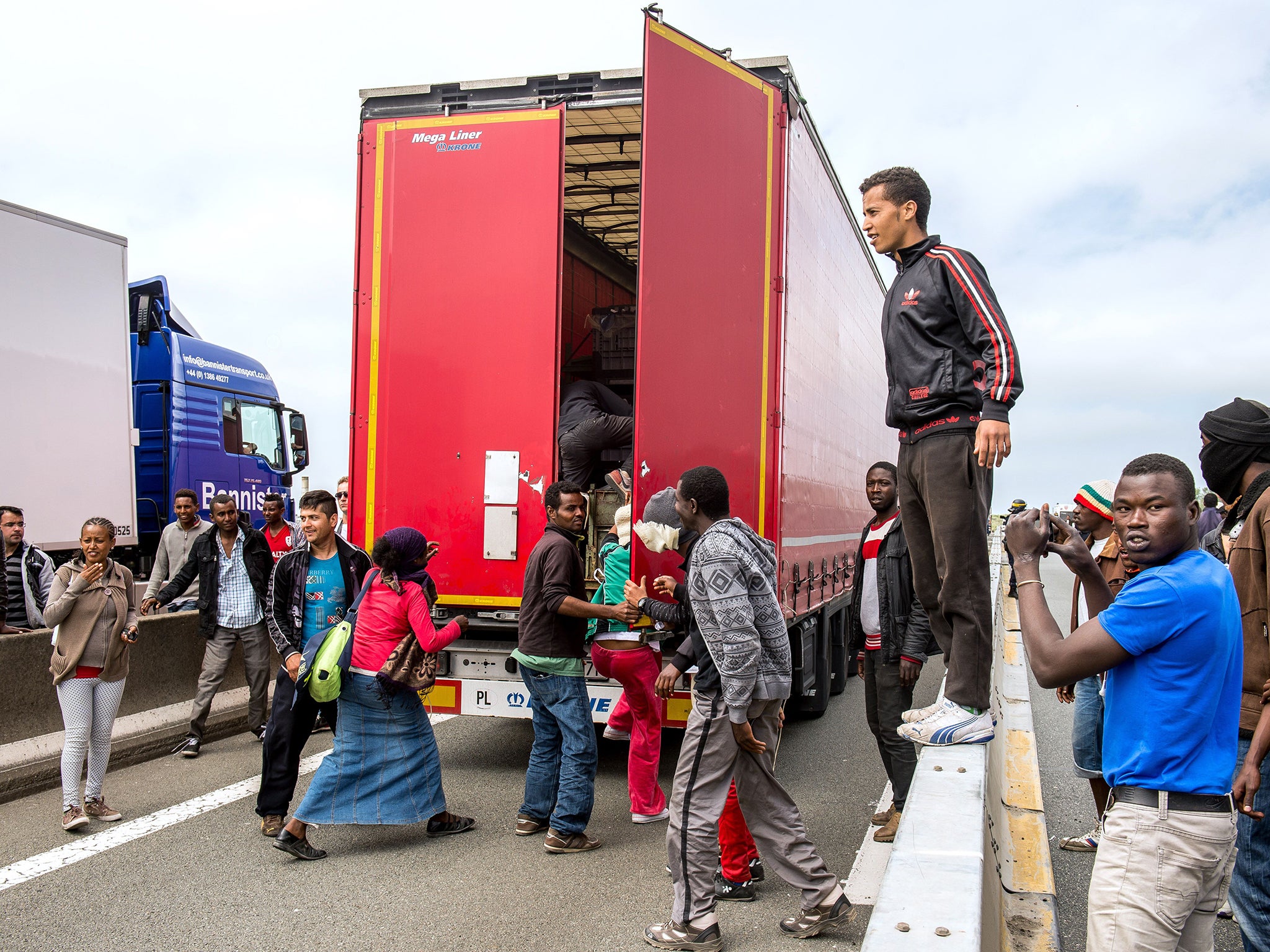 Migrants are swarming trucks heading for Britain as the strike by ferry workers cause miles of hold-ups in Calais