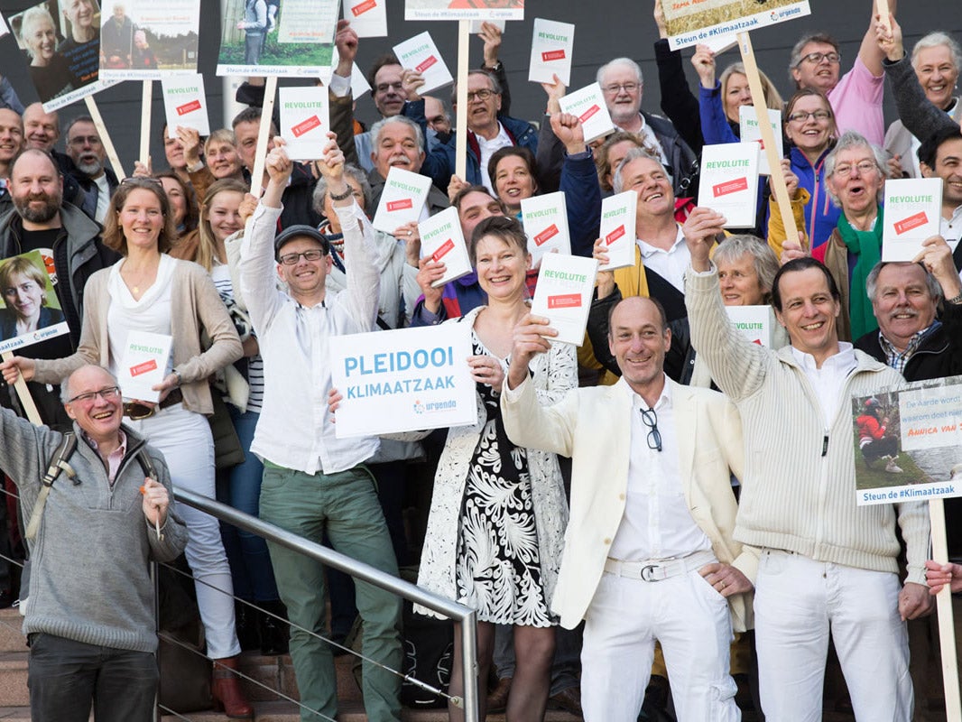 Climate change campaigners outside The Hague district court after hearing emissions verdict