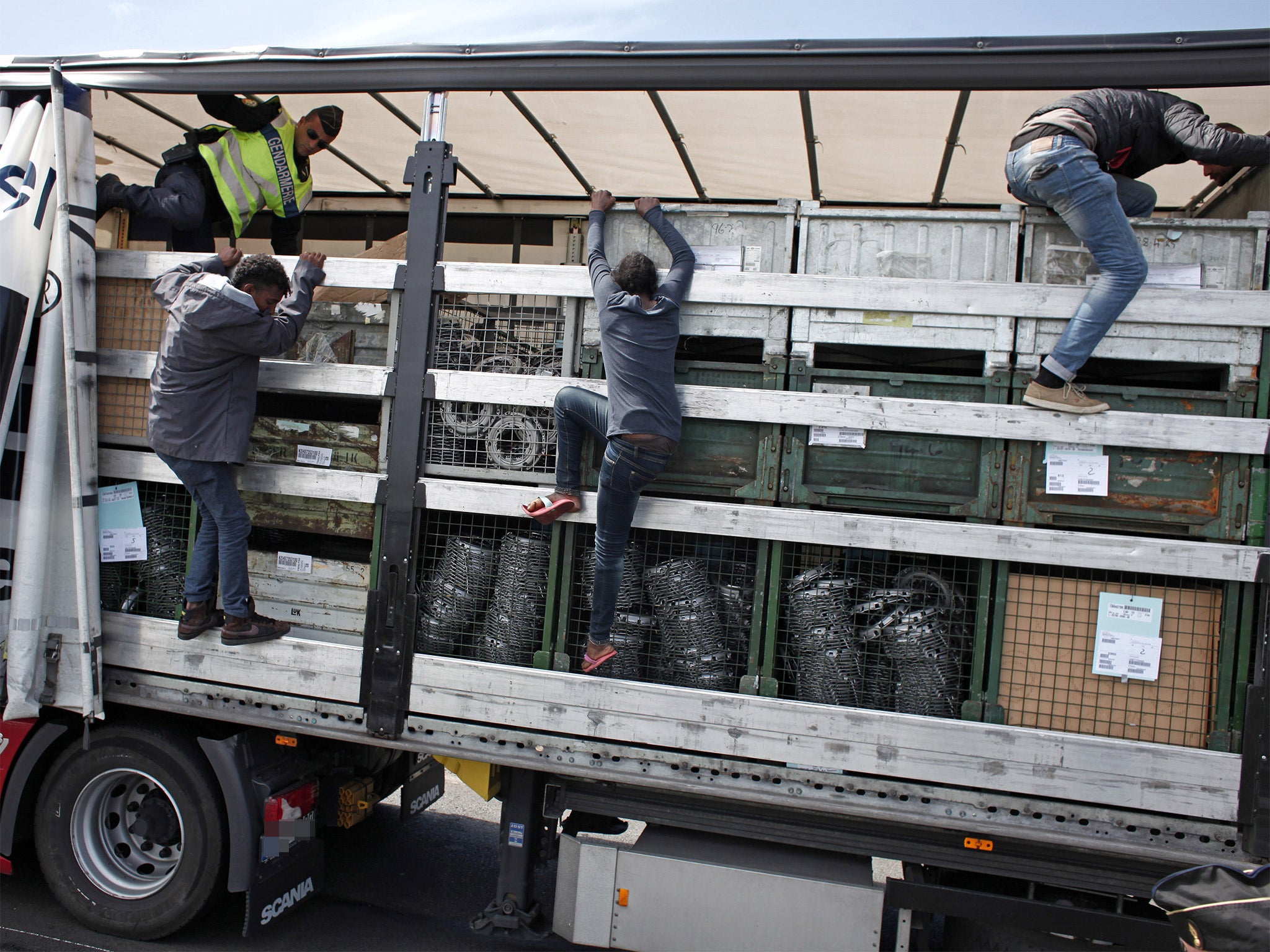 Migrants jump out of a lorry after being discovered by French gendarmerie officers