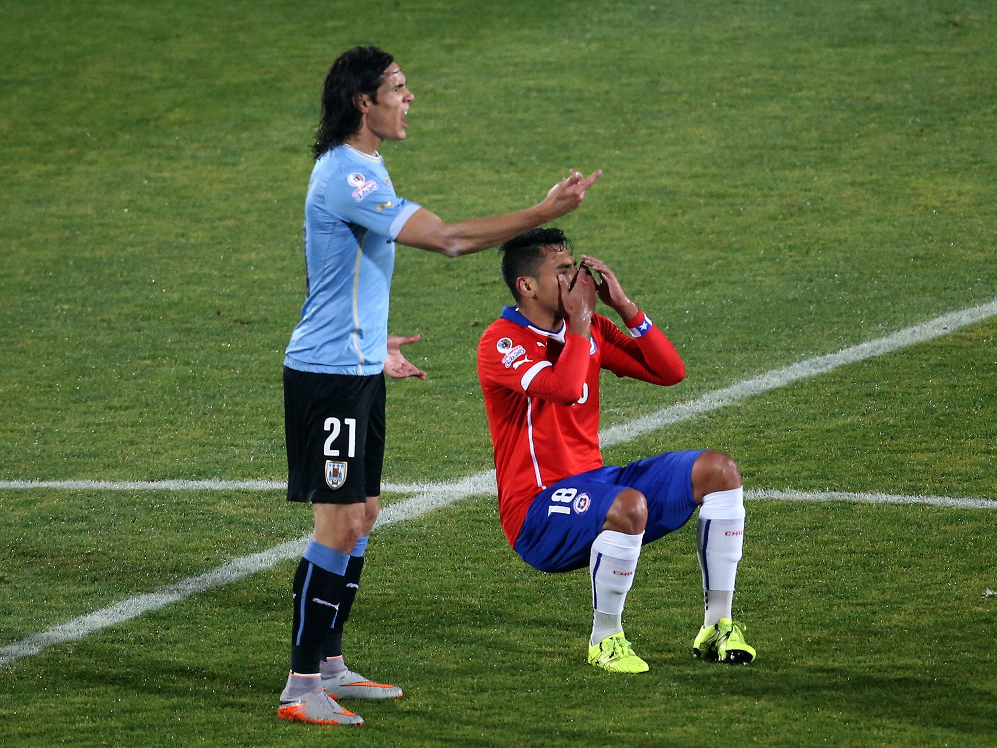 Gonzalo Jara falls down after clashing with Edinson Cavani