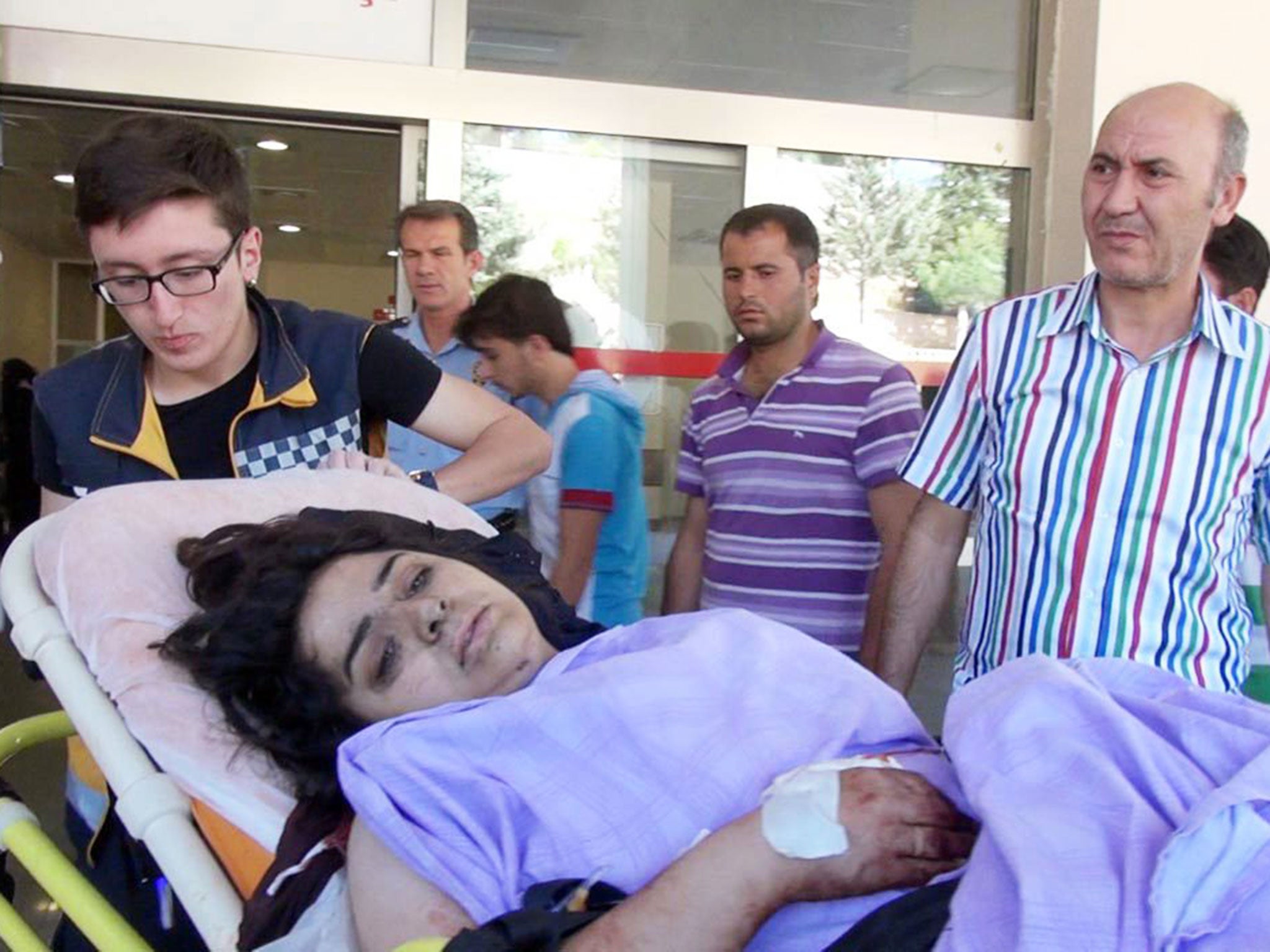 People help an injured woman after an Isis attack in Kobani