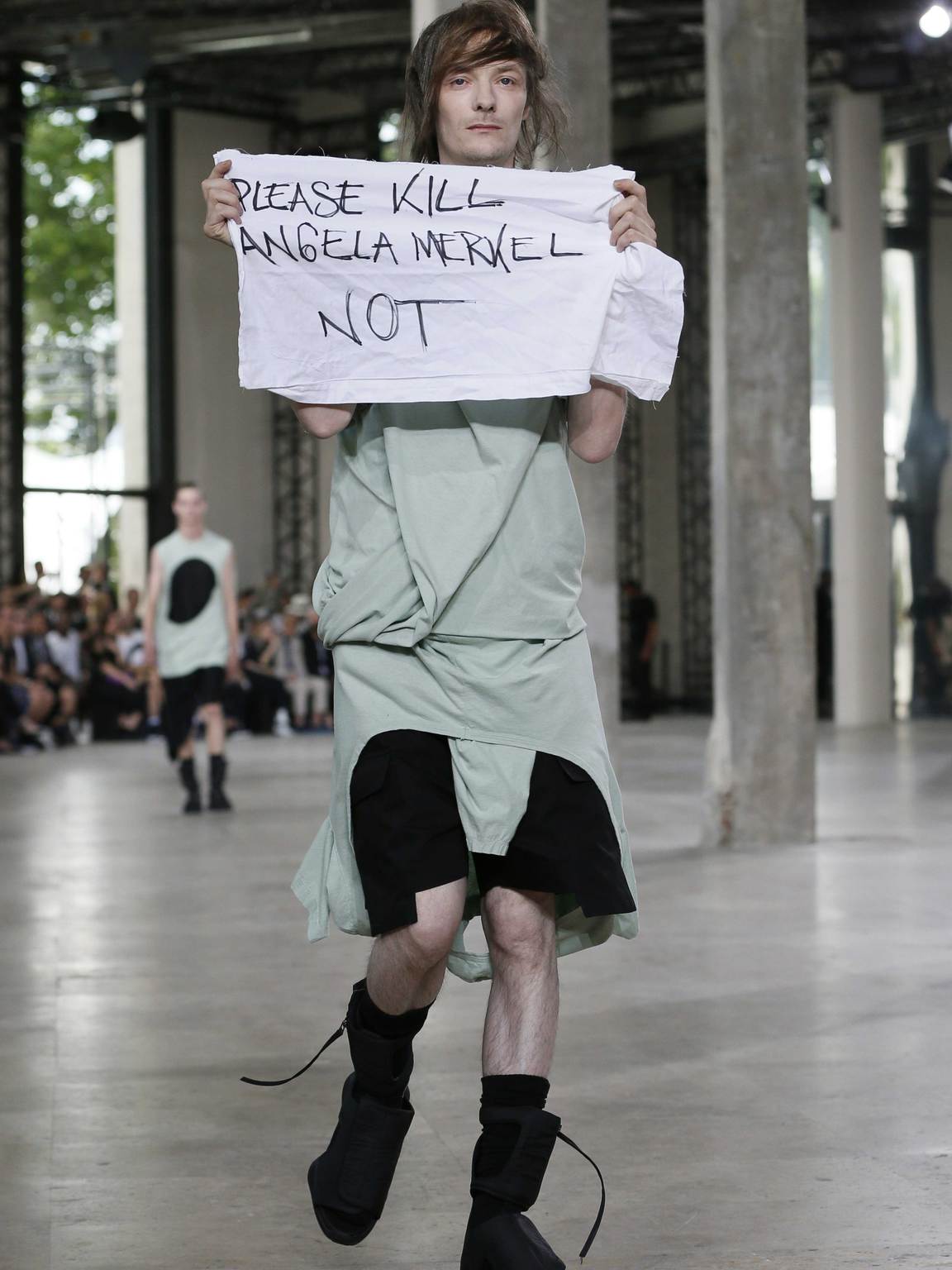 A model makes a protest at the Rick Owens spring/summer 2016 show