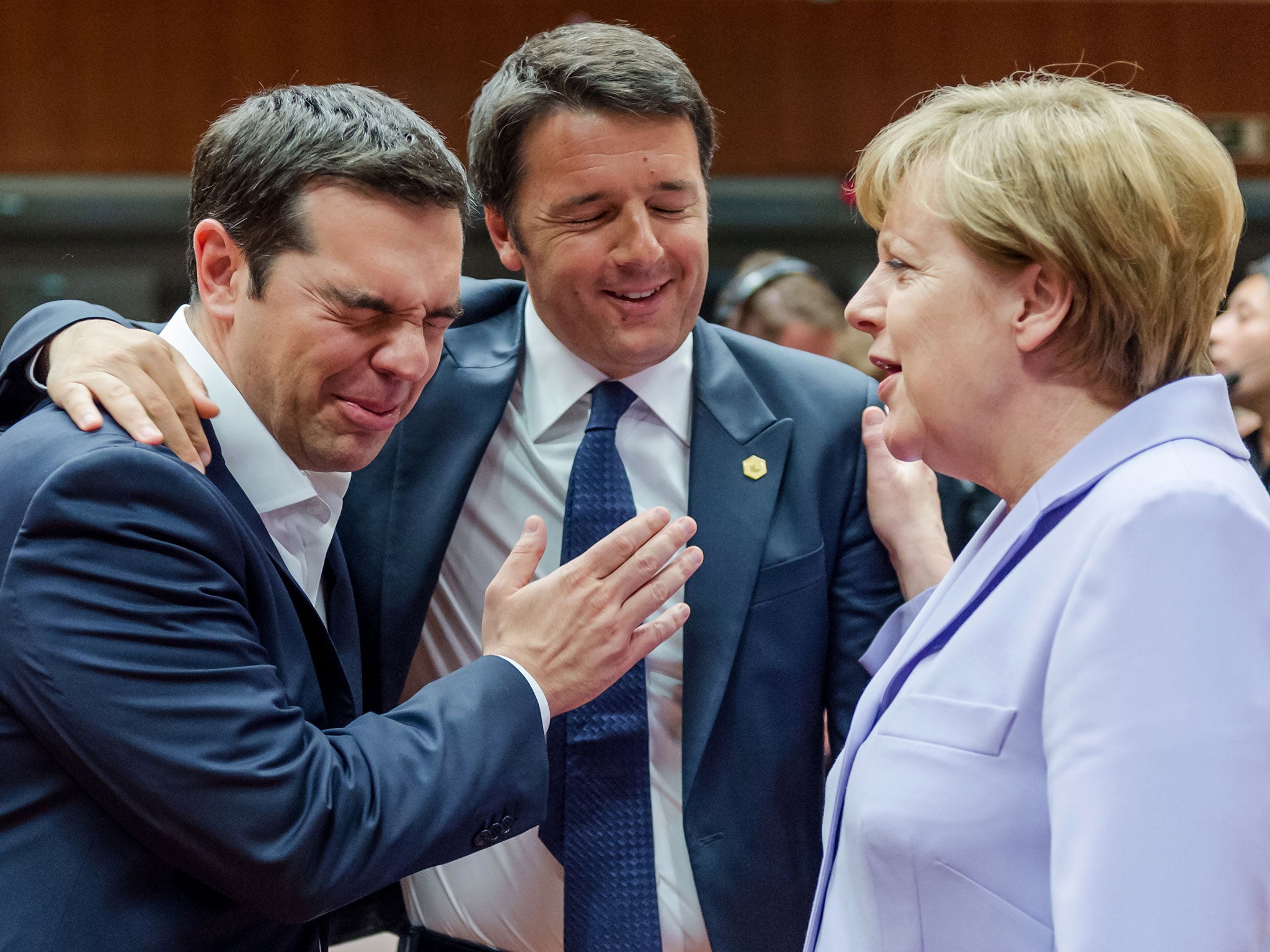 Italian Prime Minister Matteo Renzi, center, speaks with Greek Prime Minister Alexis Tsipras, left, and German Chancellor Angela Merkel during a round table meeting at an EU summit in Brussels