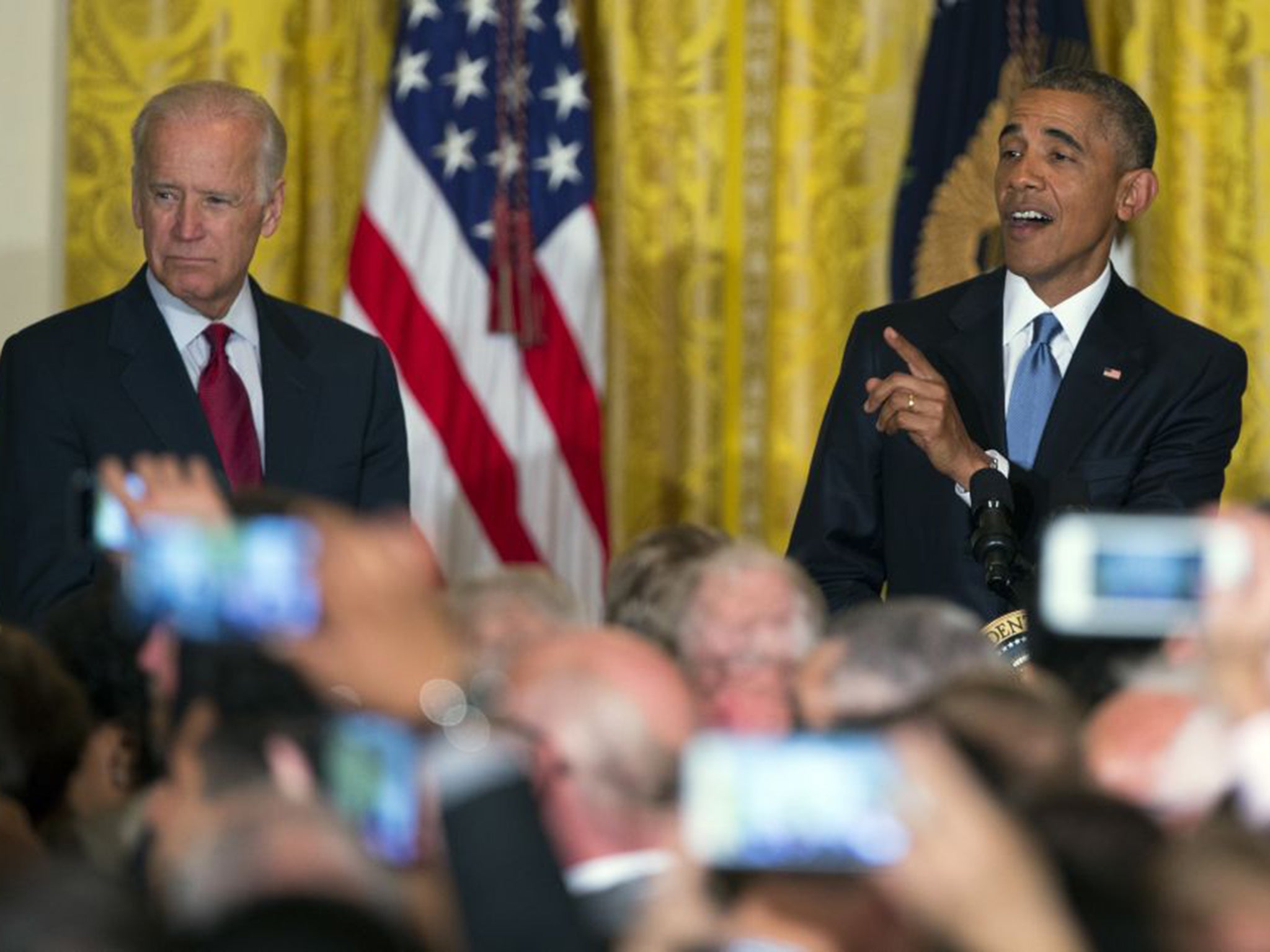 Good call: Joe Biden watches as Barack Obama coolly responds to a heckler at the White House