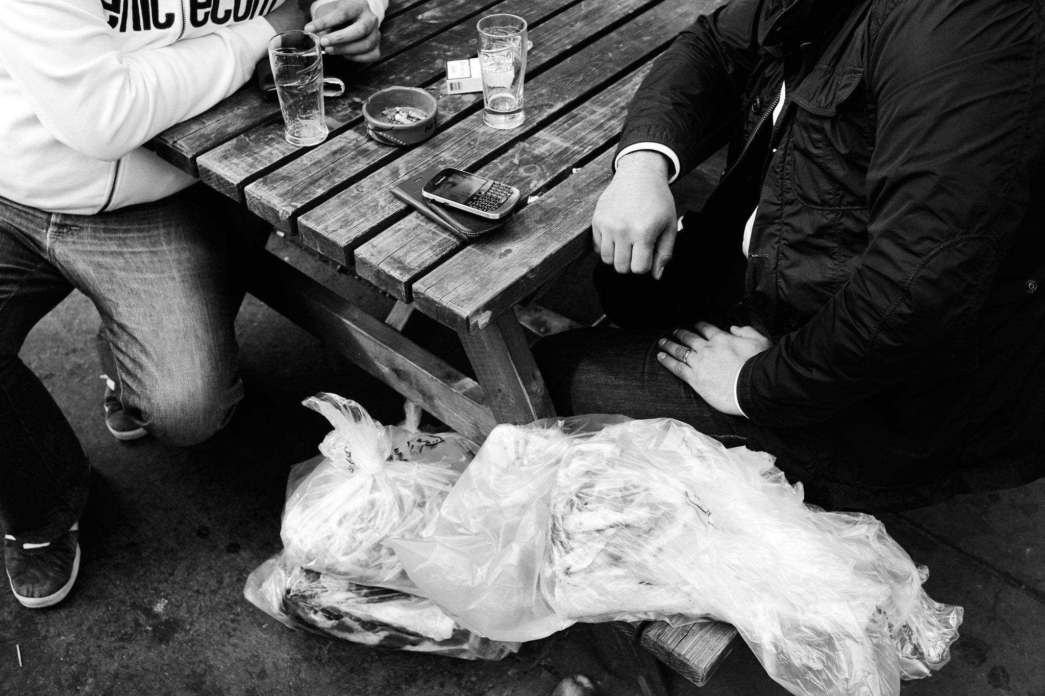 Market shoppers enjoy a morning beer with bags of meat, destined for a barbecue