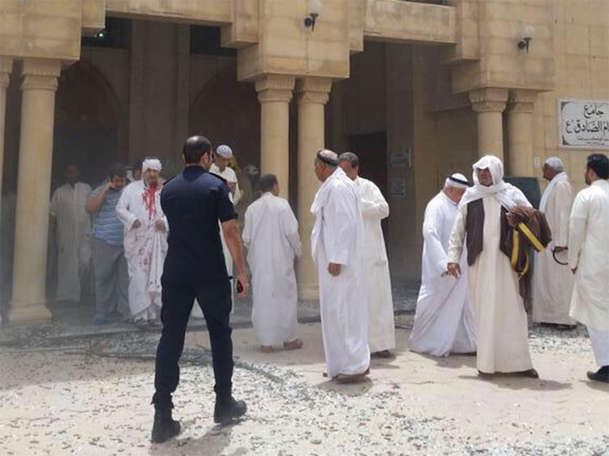 People file out of the mosque after the bomb attack at the al-Imam al-Sadiq mosque