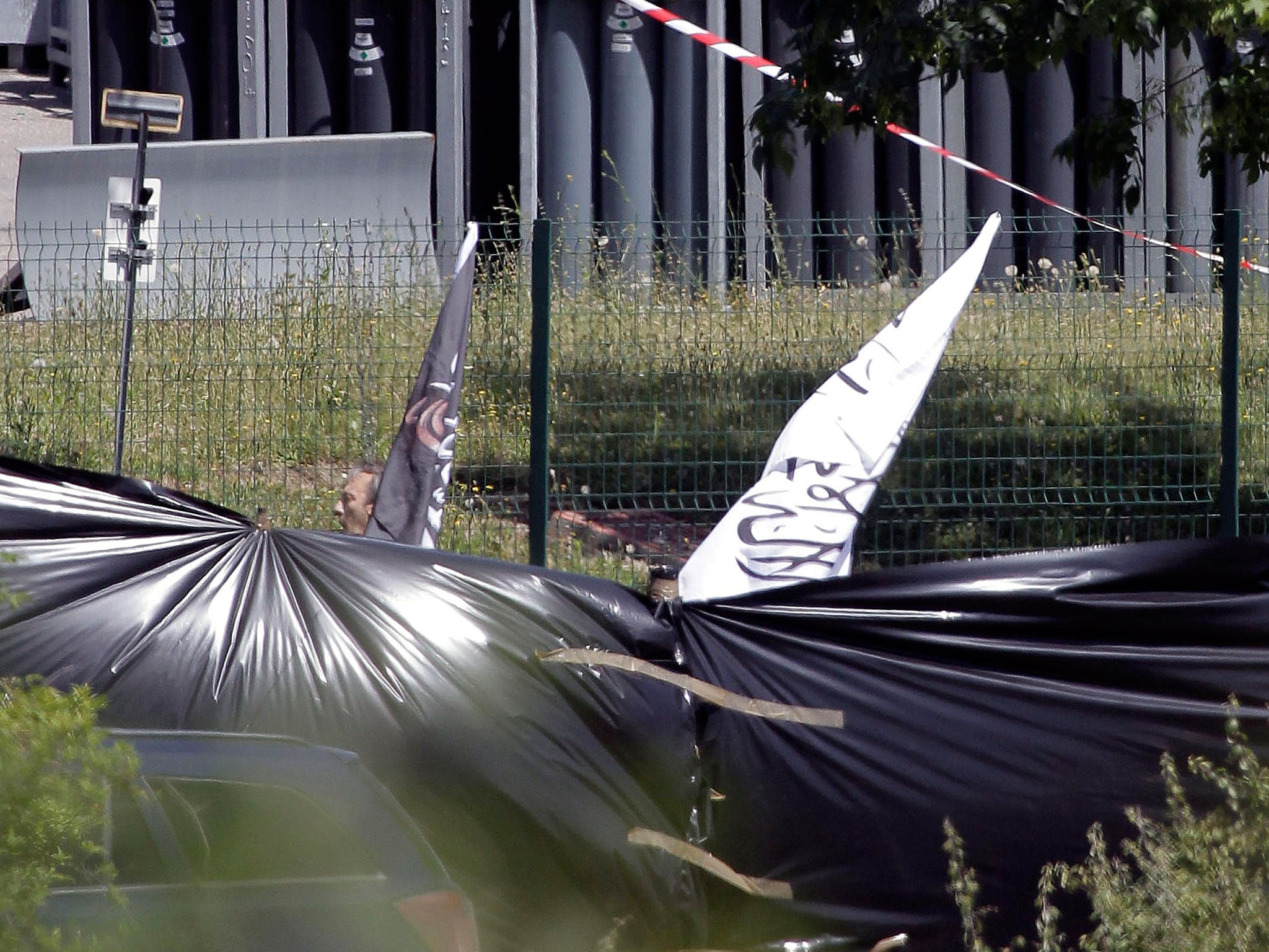 Police investigators carry banners with illegible Arabic writing on them