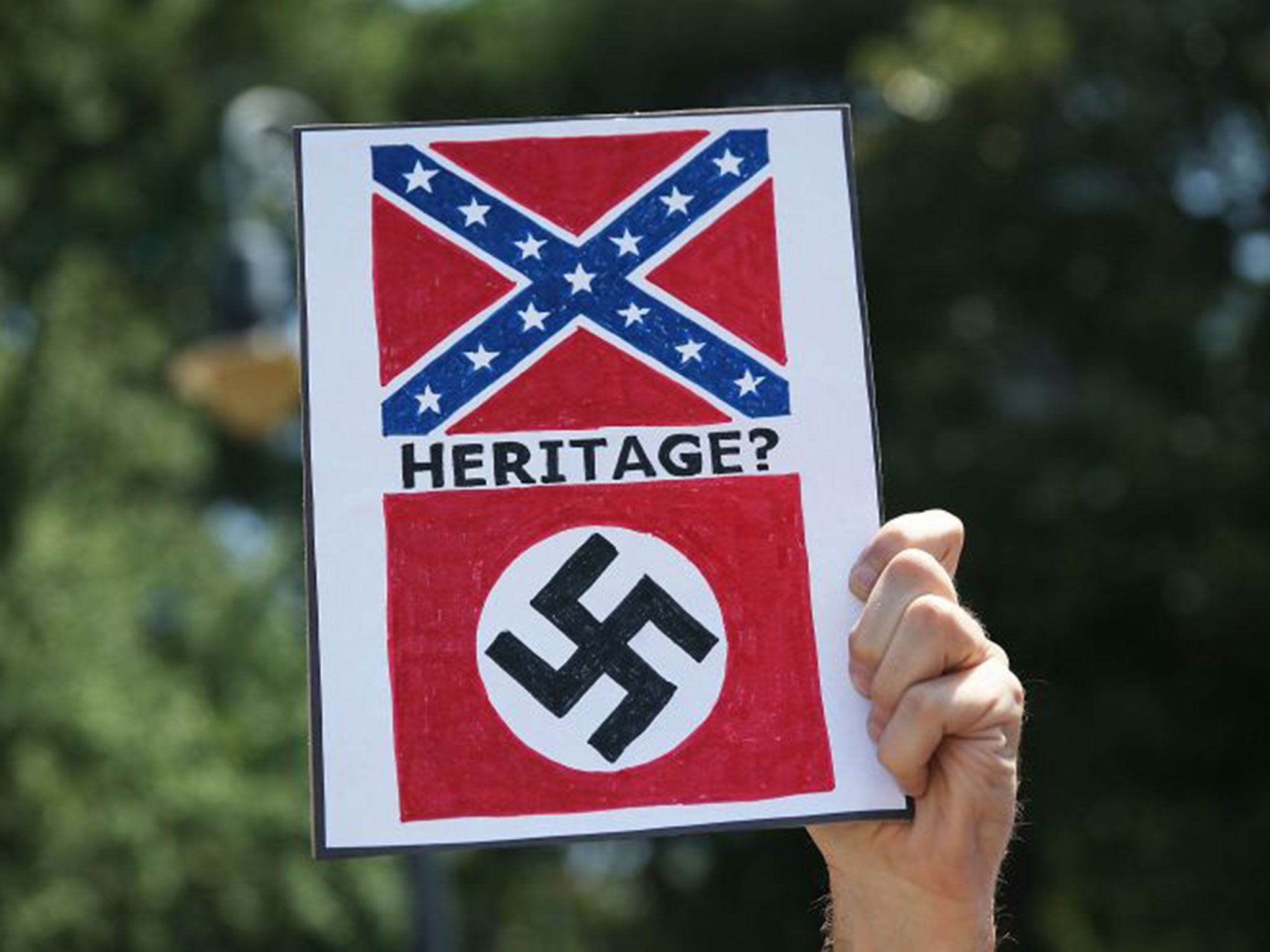 A sign equates the confederate flag with the nazi flag as people attend a protest in support of a confederate flags removal from the South Carolina capitol grounds